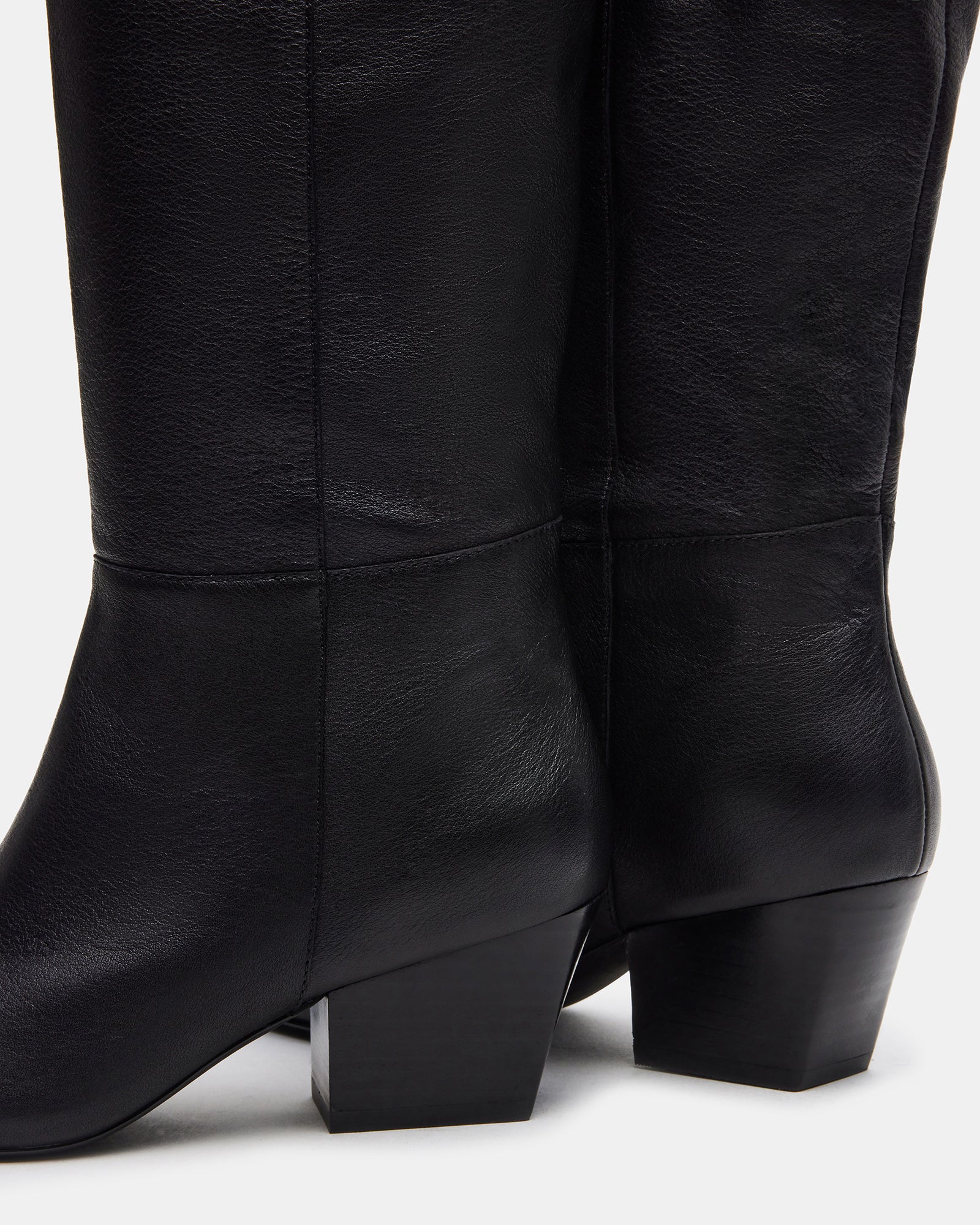 Back view of wide calf knee high boots on sidewalk, highlighting shaft height and stitching.