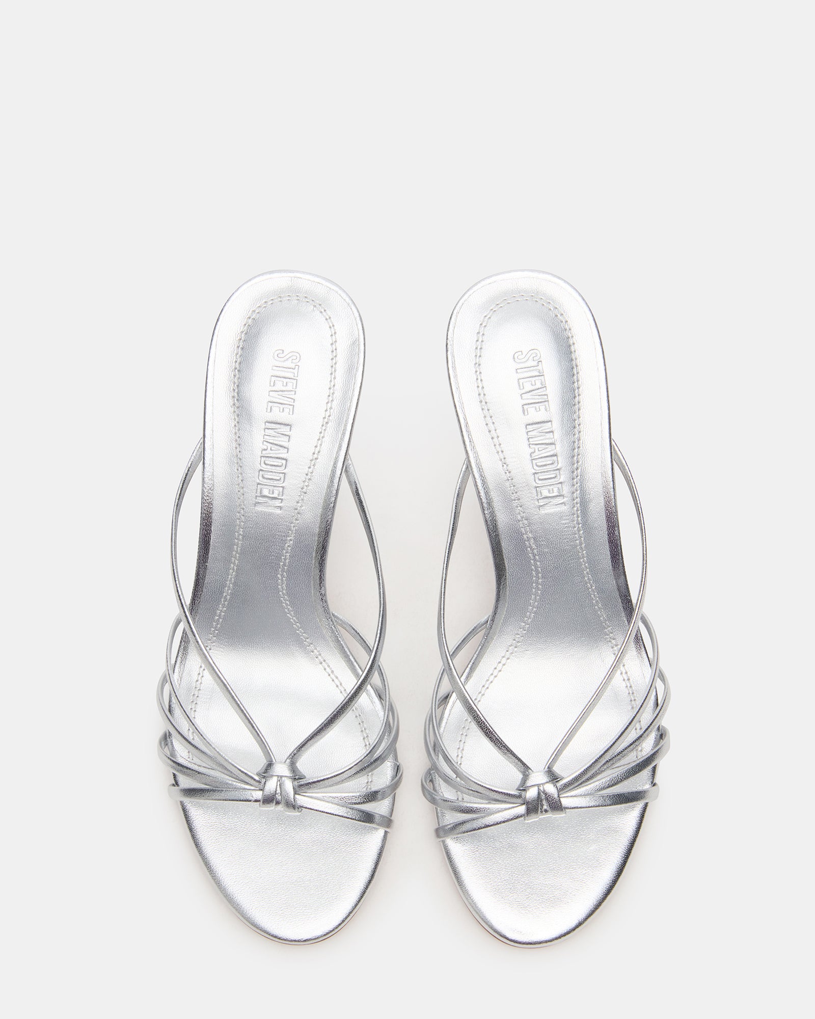 EDNA silver kitten heel mules on marble background with soft lighting