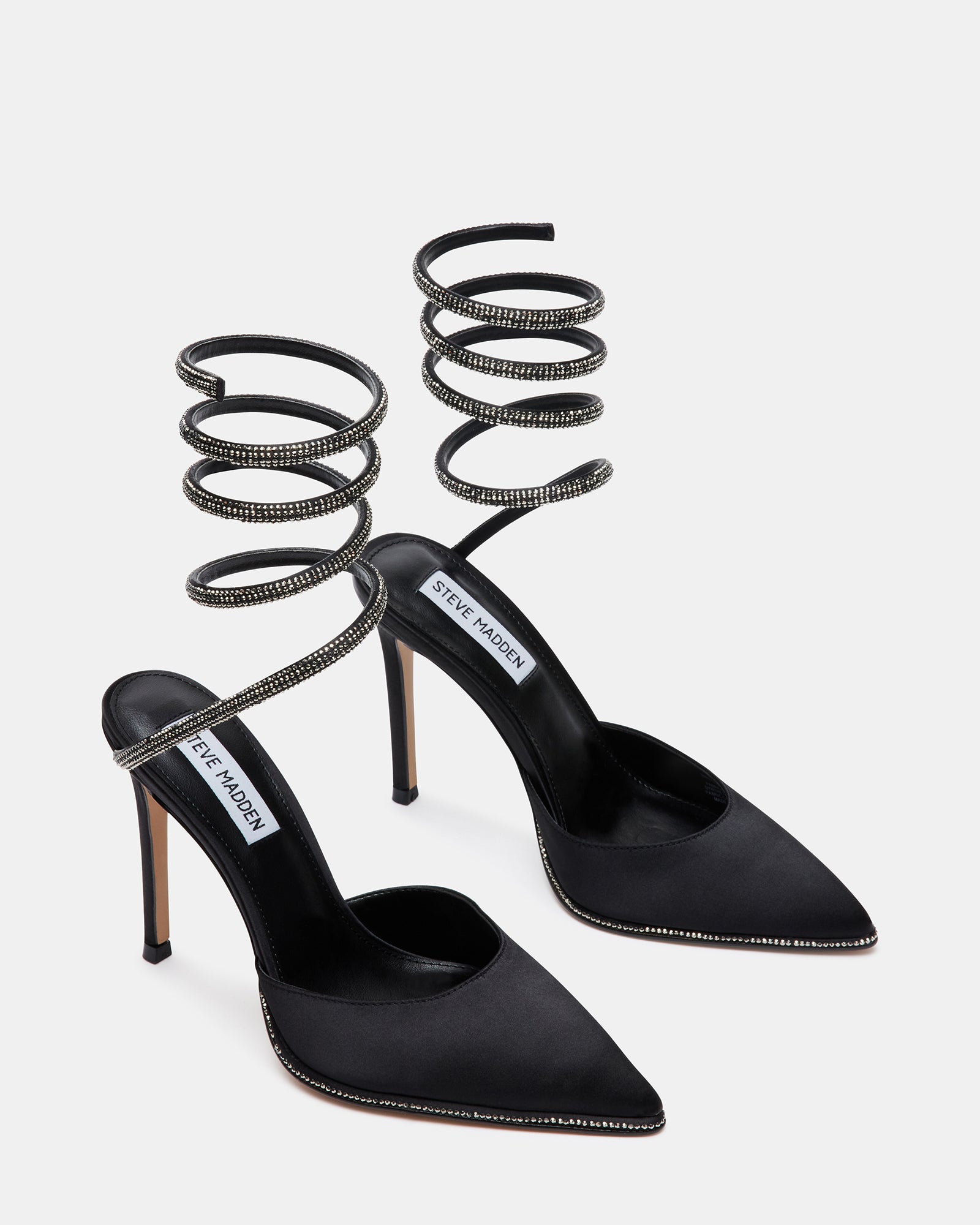 Close-up of pointed toe with rhinestone welt on black satin pumps