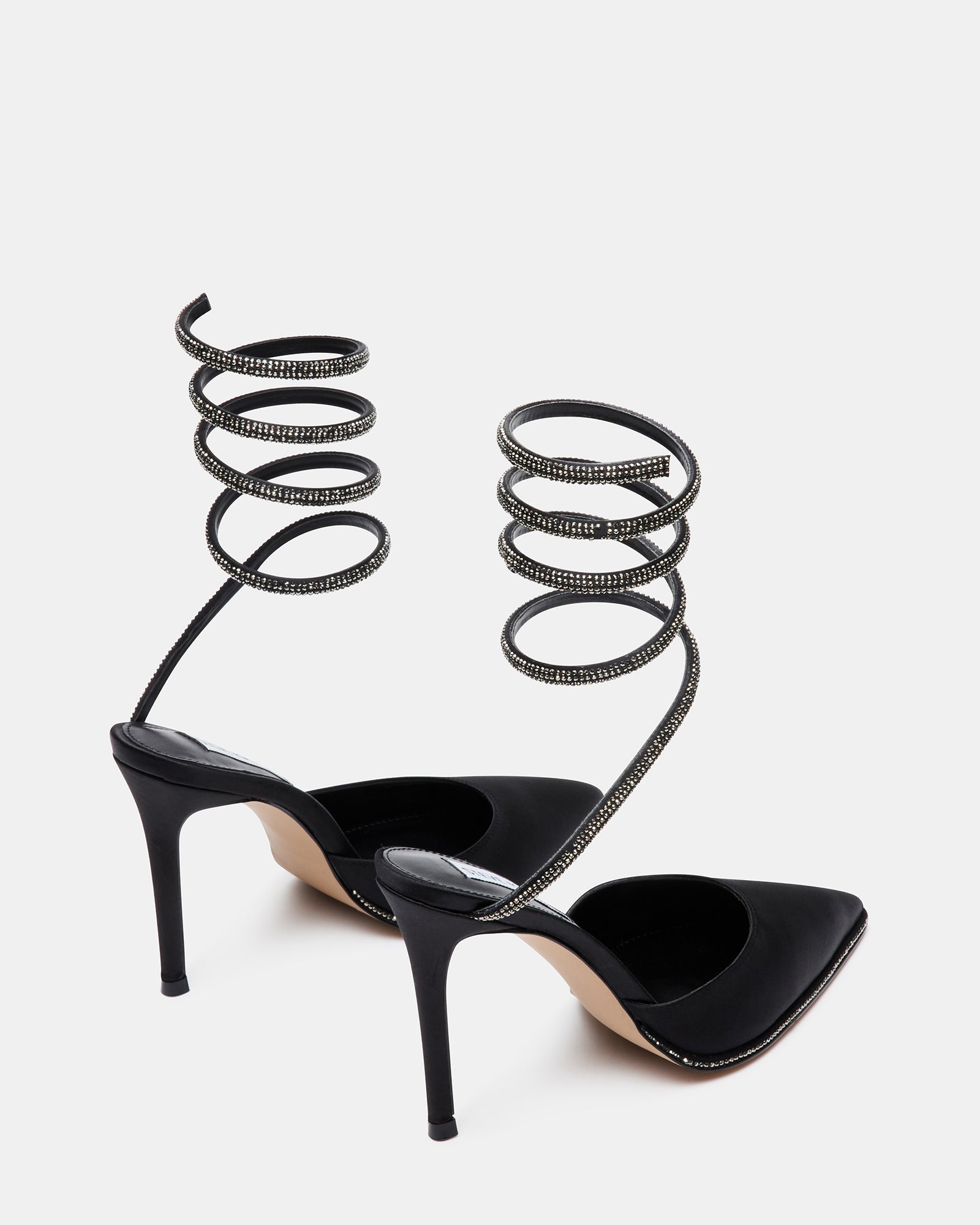 Close-up of pointed toe with rhinestone welt on black satin pumps
