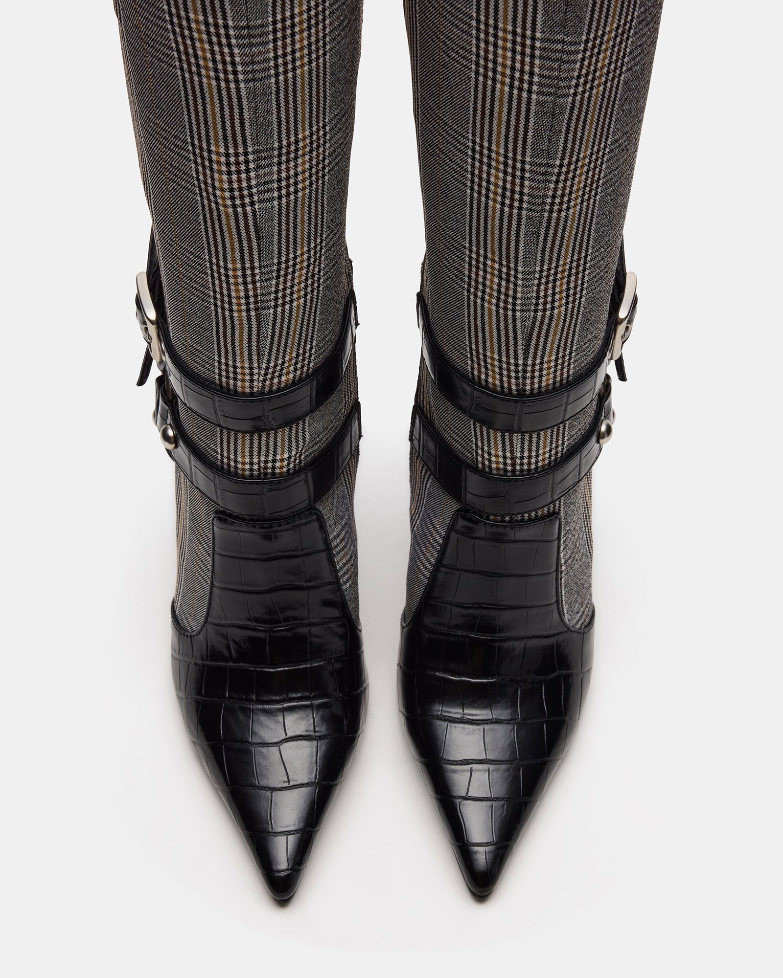 Side view of black knee-high boots with buckle accents and pointed toe