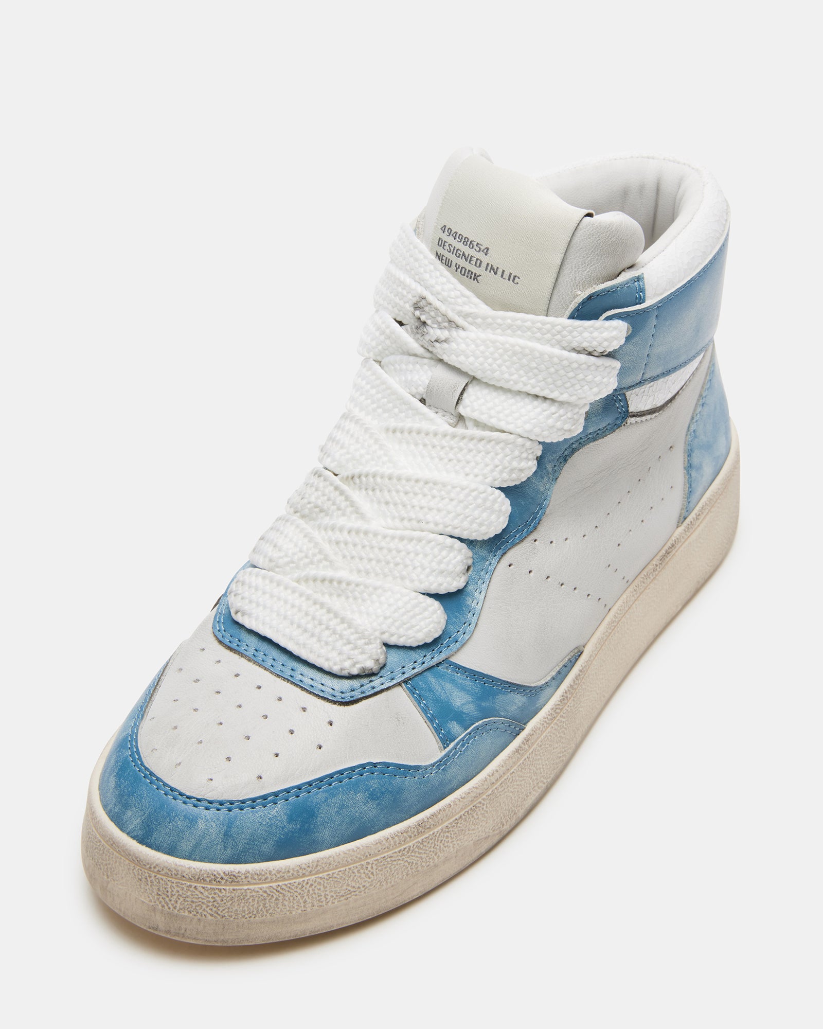 Fashionable women wearing blue multi distressed high top sneakers outdoors