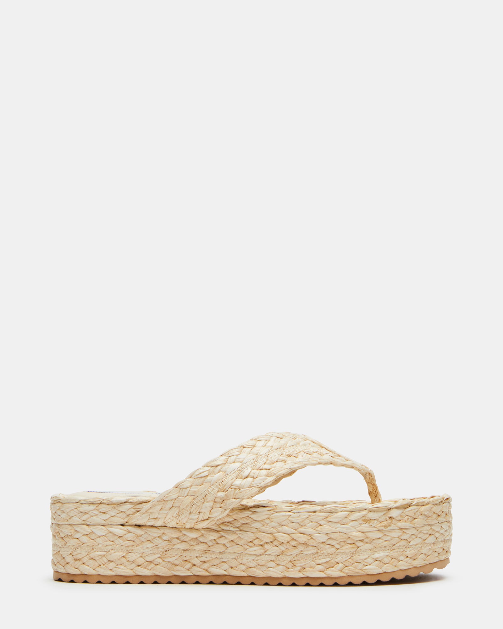 Side view of Steve Madden raffia sandals on sandy beach
