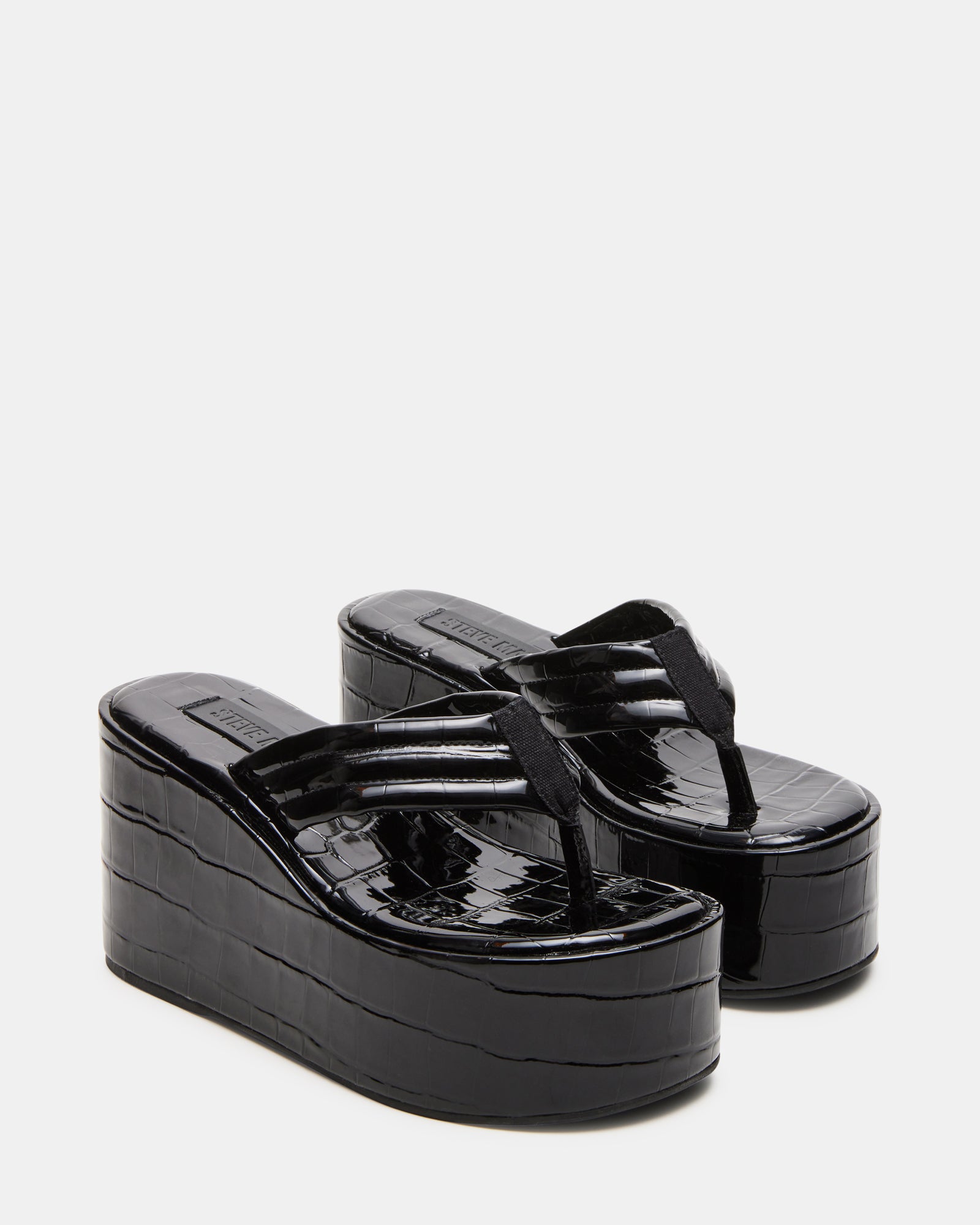 Close-up of the synthetic upper material of the black thong sandals.
