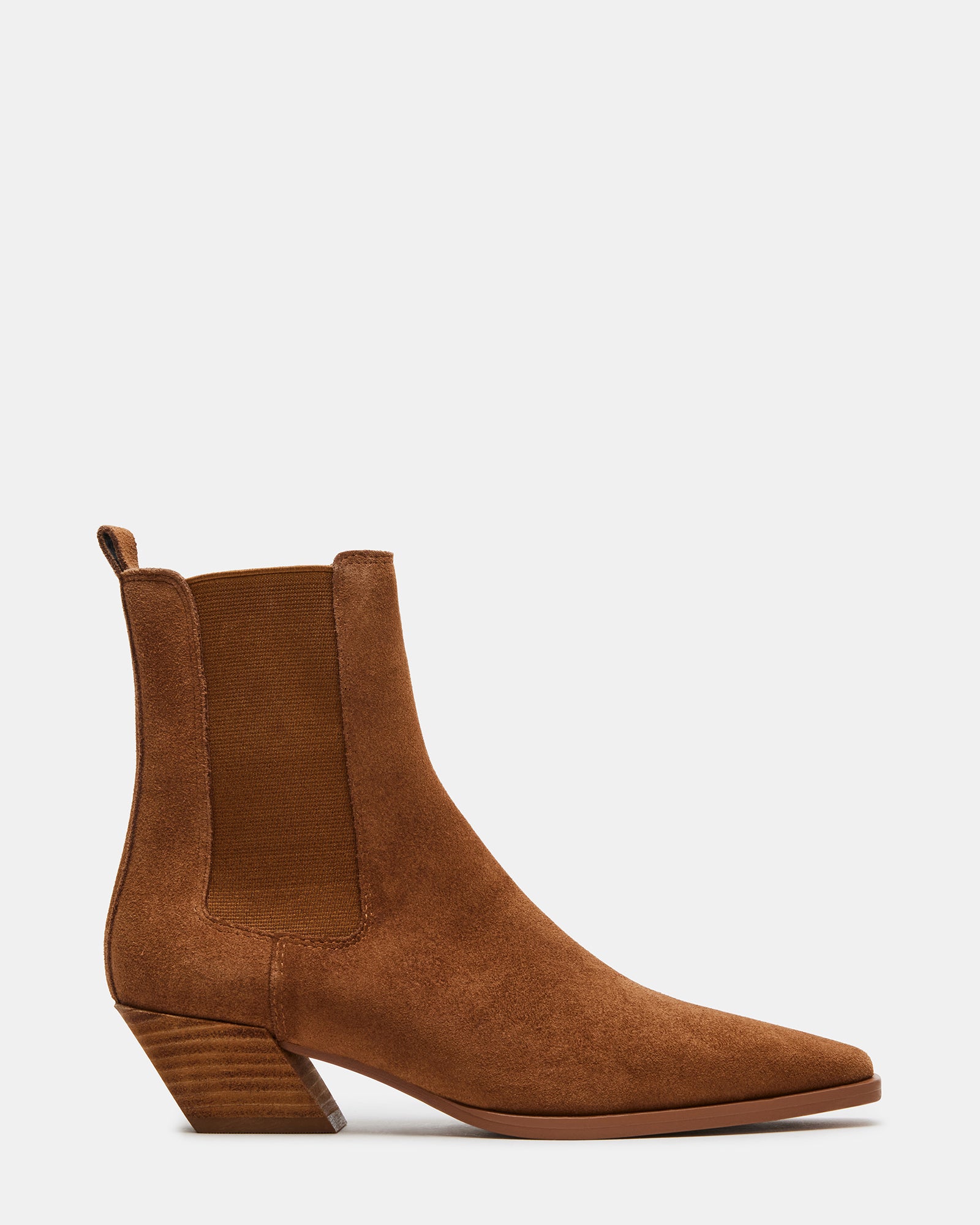 Side view of brown suede Chelsea boots on a wooden floor