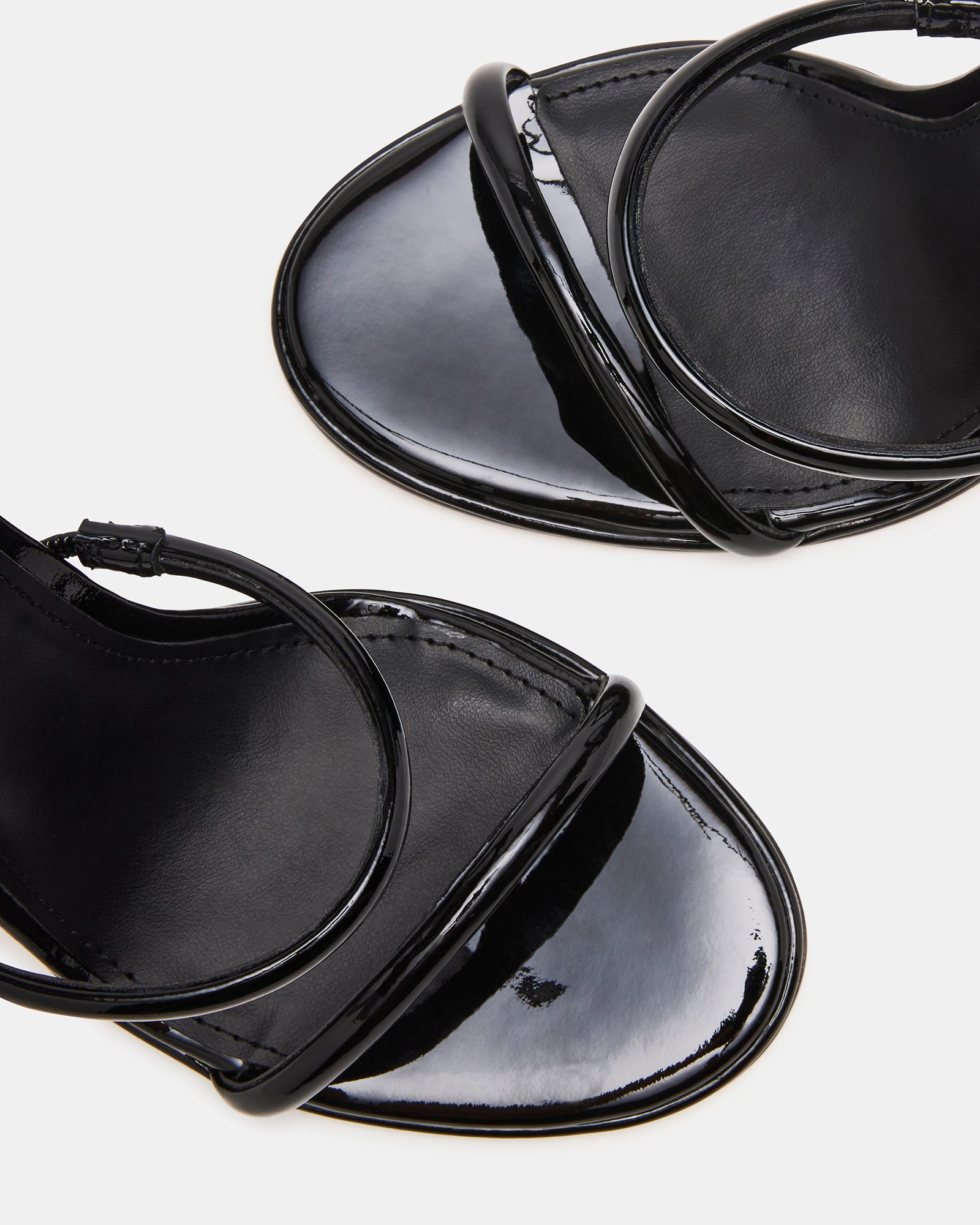 Close-up of Exotica black patent leather shoes with ankle wrap.