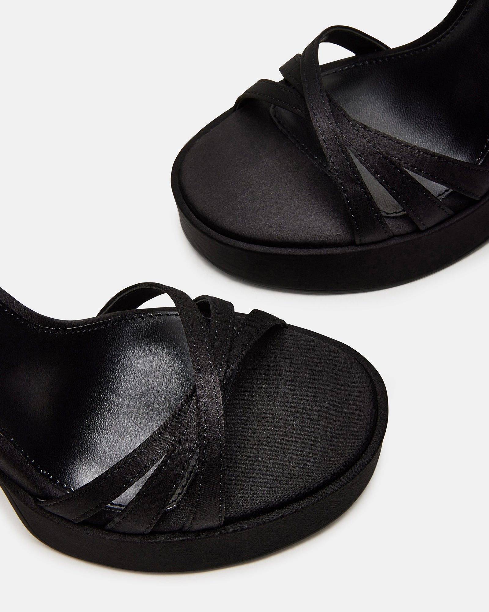 Fleet black strappy platform heels showcasing crisscross design from the back.