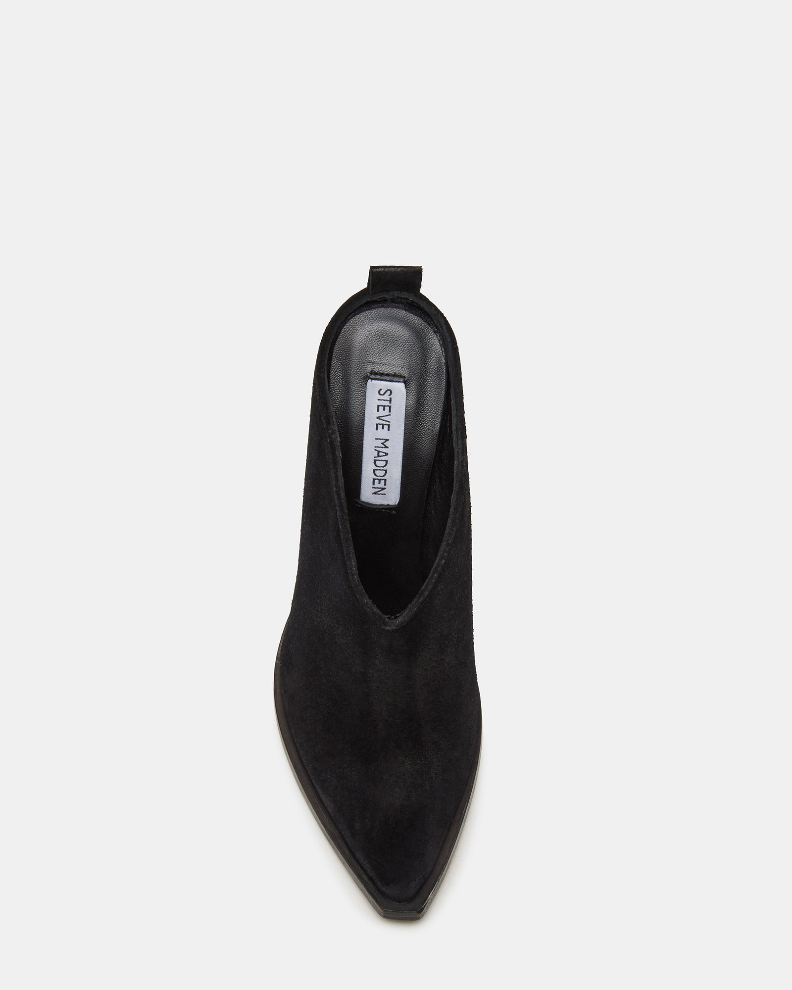 Side view of black suede heels with block heel and pointed toe, set against studio backdrop.