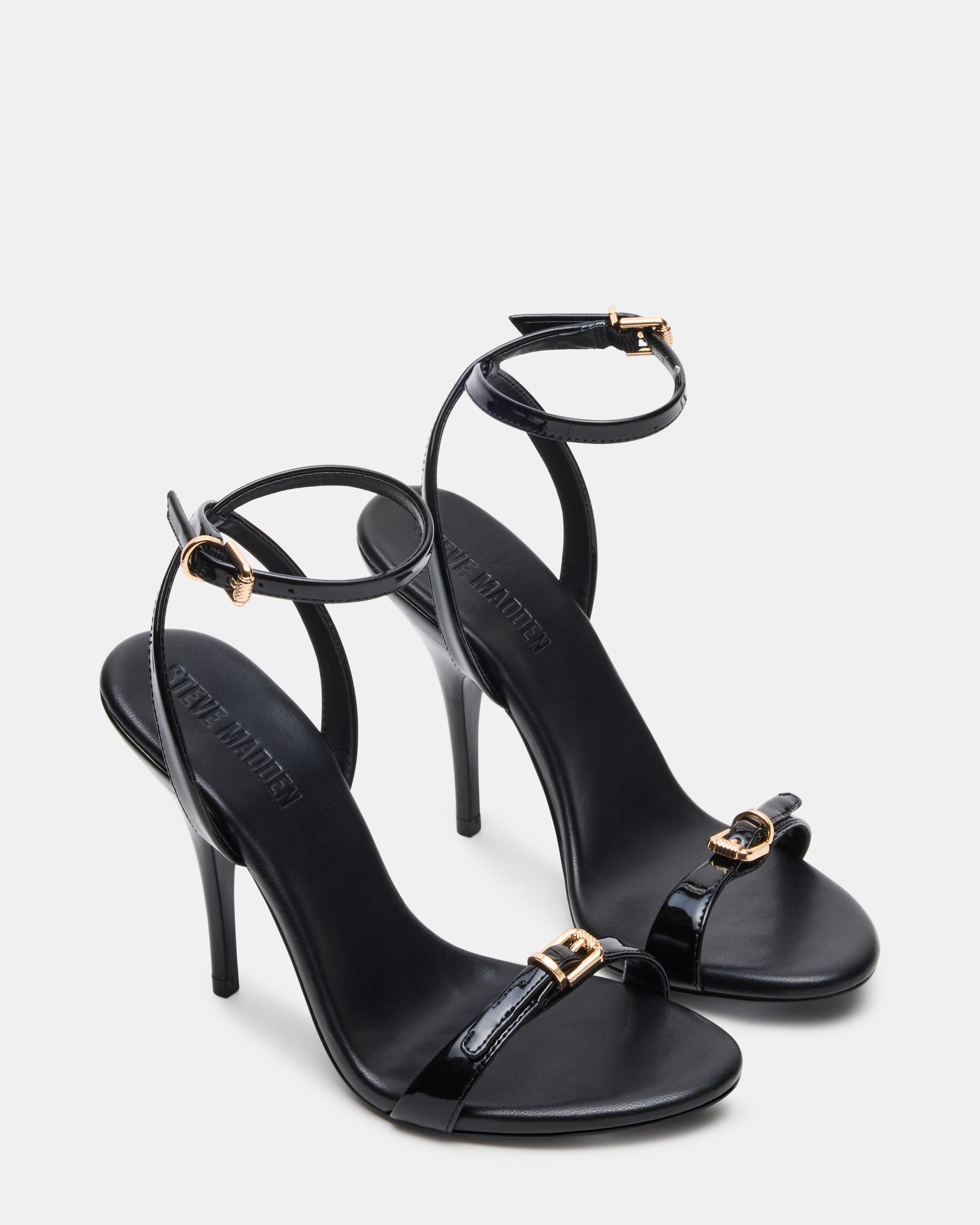 Model wearing FOXX black stiletto heels at a formal event.