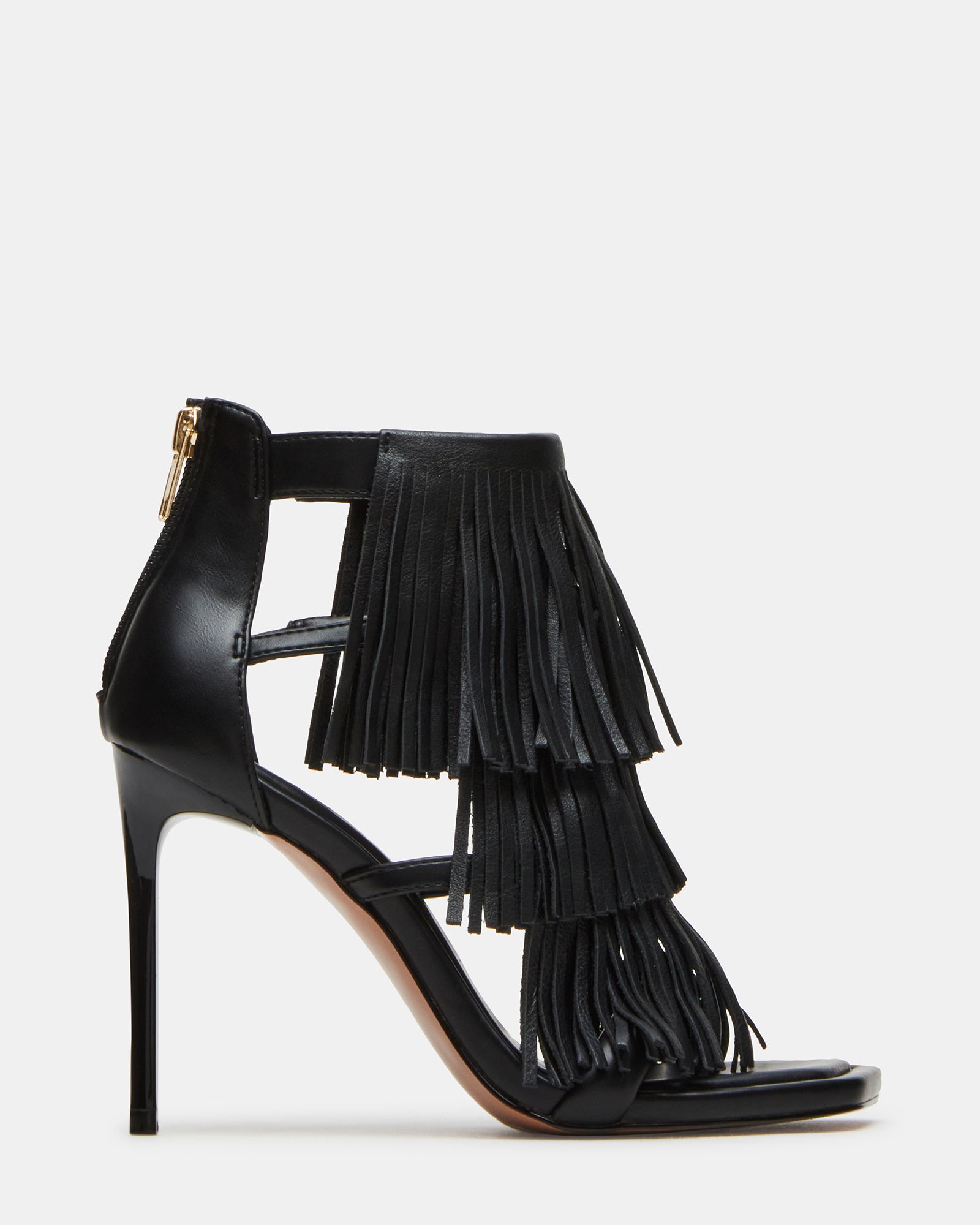 Side view of black leather heels with fringe, styled for evening wear