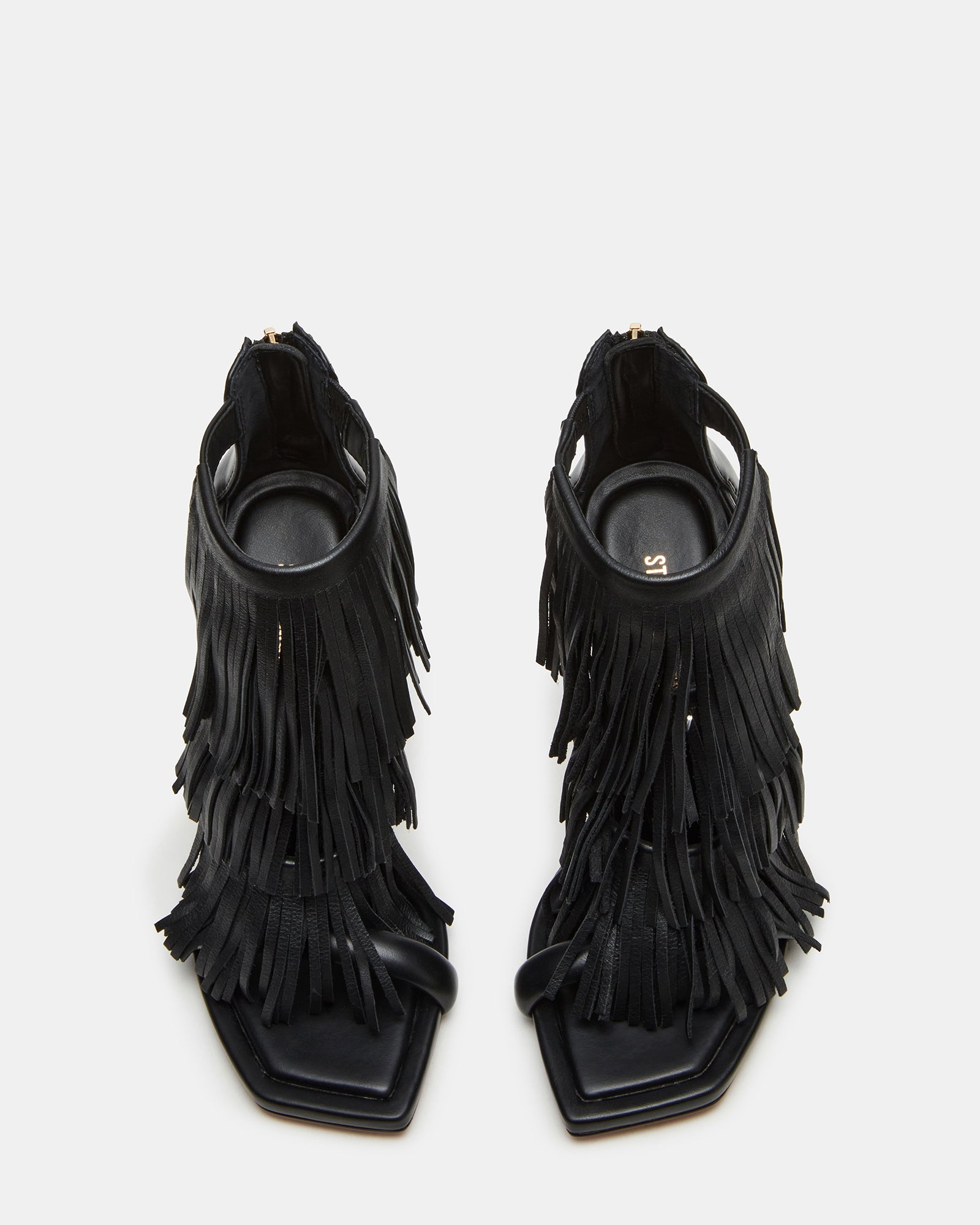 Side view of black leather heels with fringe, styled for evening wear