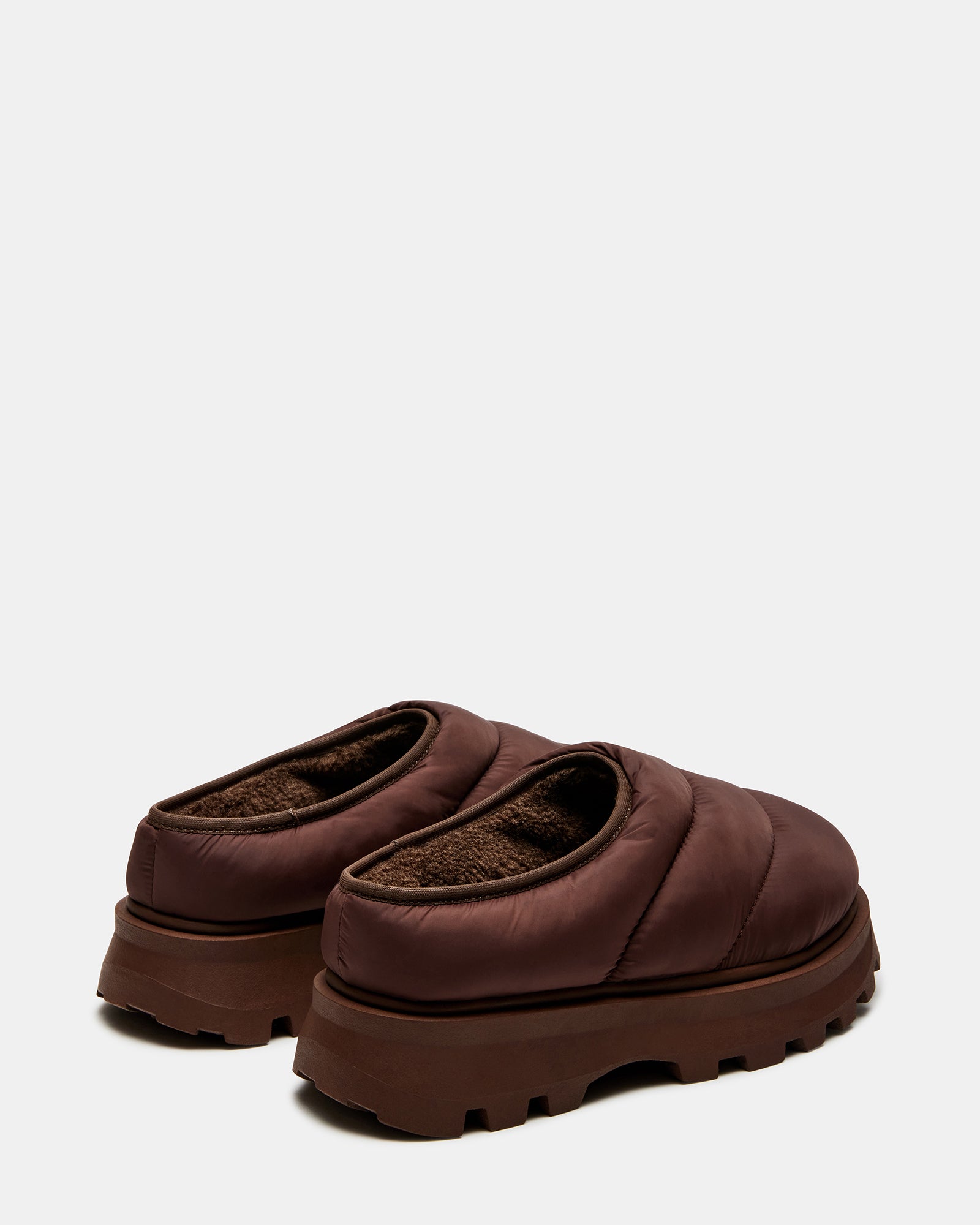 Frost Brown slip-on shoes on a wooden bench, showcasing the faux fur lining