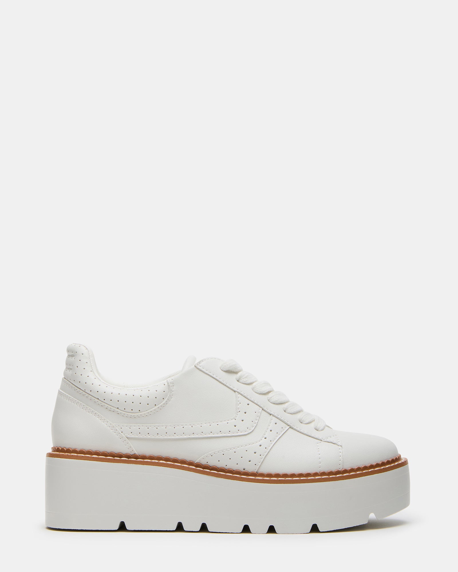 Side view of chunky platform shoes in white vegan leather on sidewalk setting.
