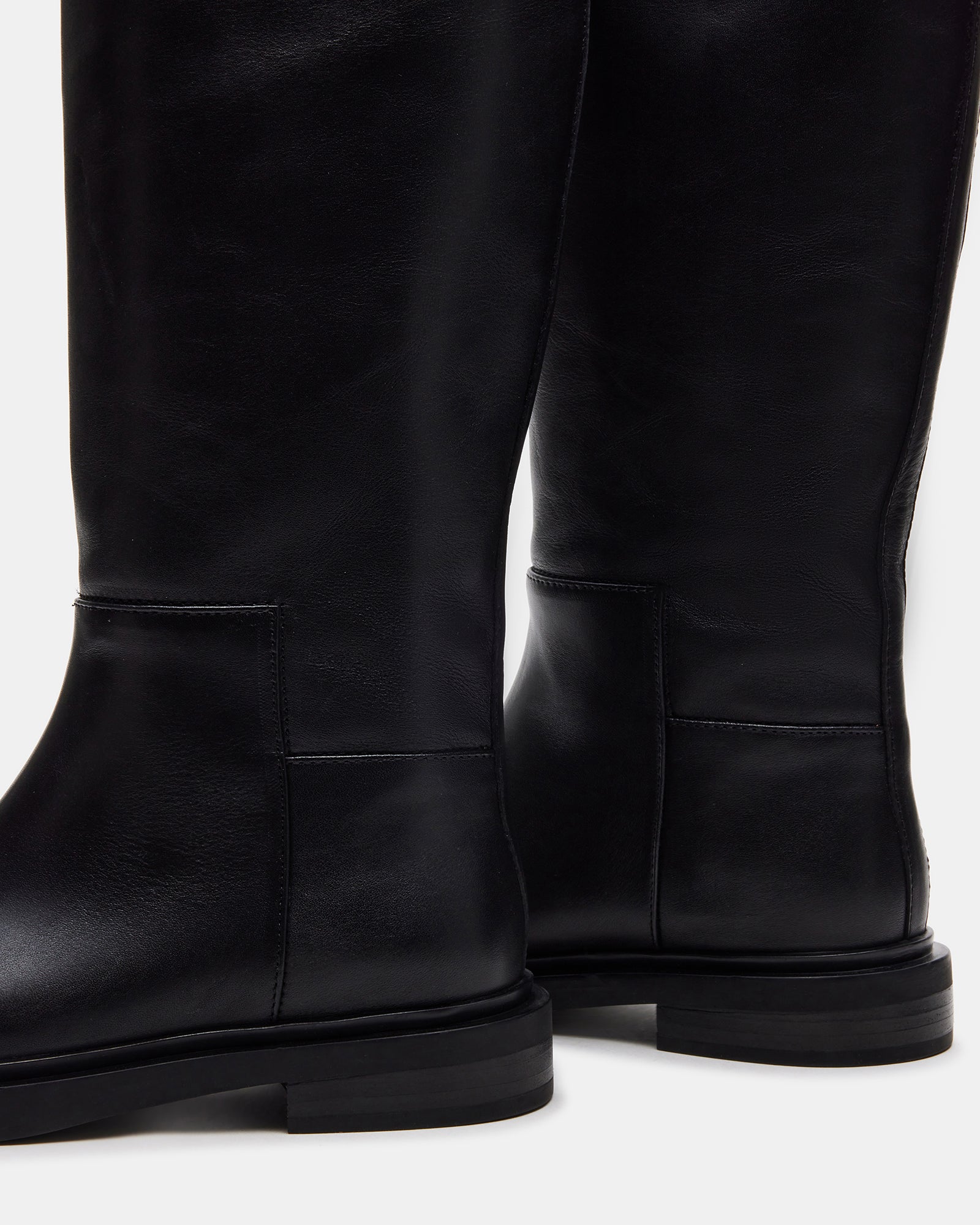 Side view of black leather boots, emphasizing the sleek design and fit.