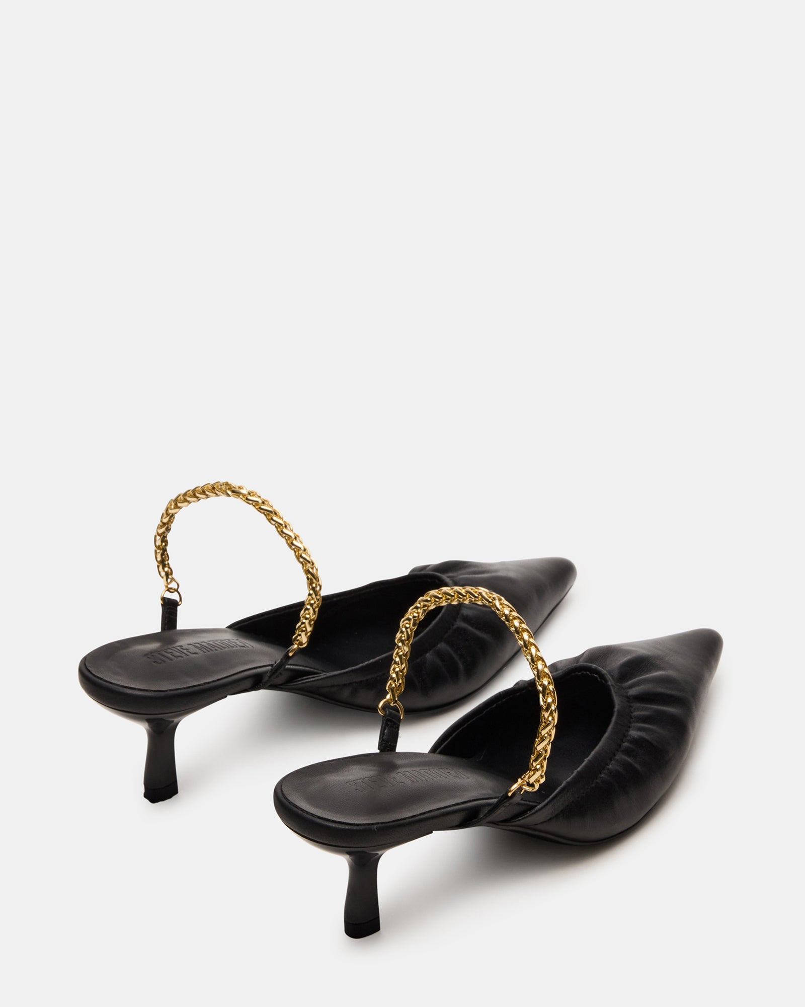 Close-up of the luxurious leather upper of black kitten heel mules.