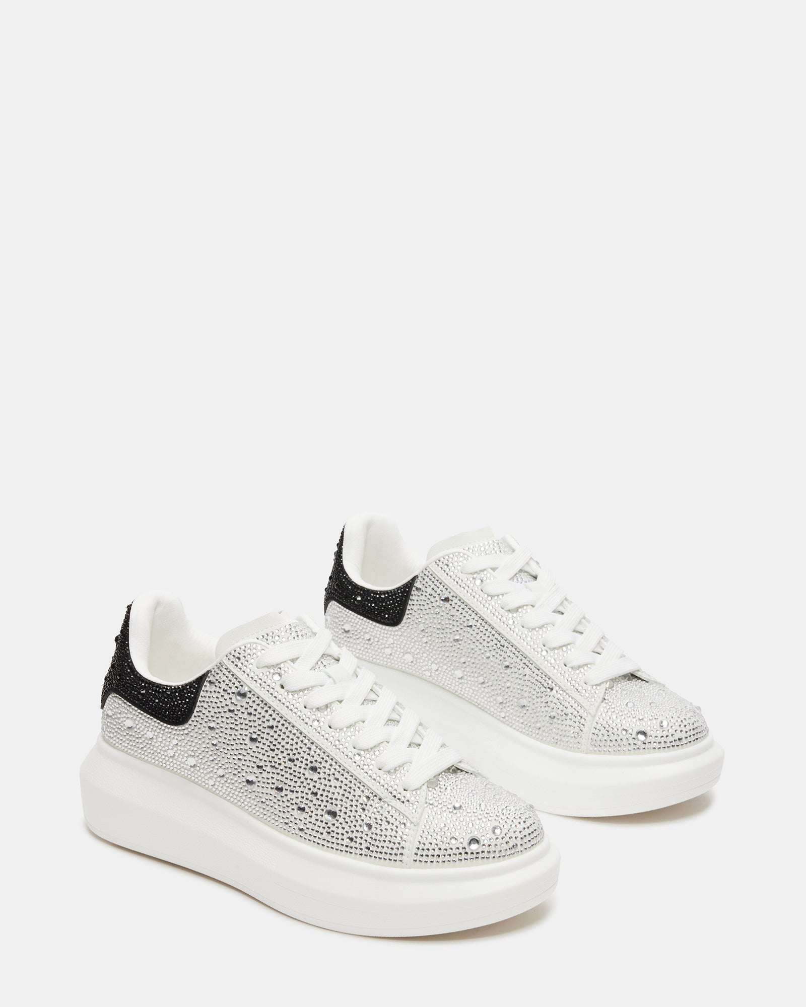 Top-down view of white platform sneakers in urban setting