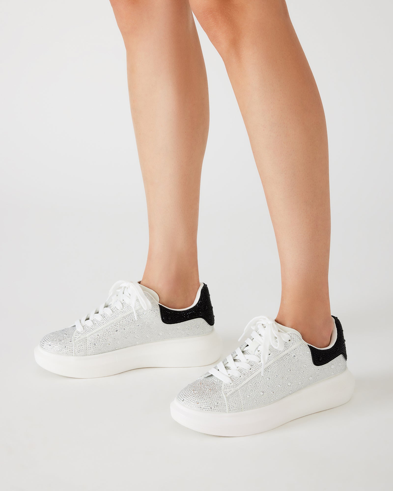 Side angle showing black platform sneakers with shimmer details