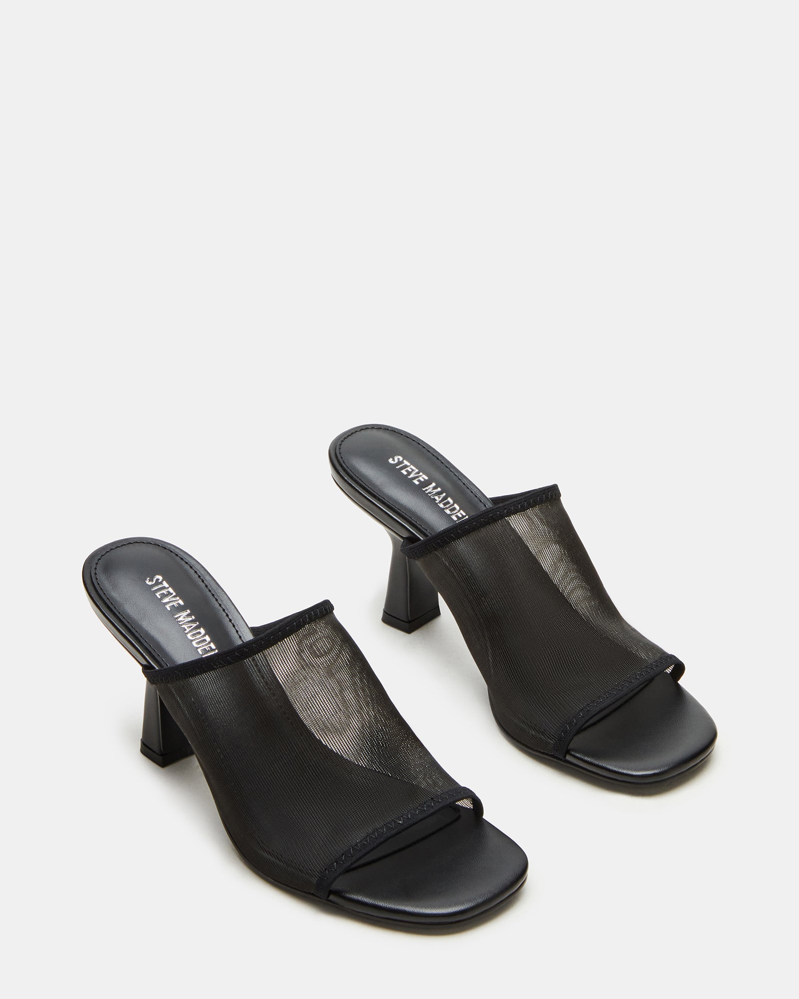 Gleam Black mules worn with a chic outfit, perfect for a night out.