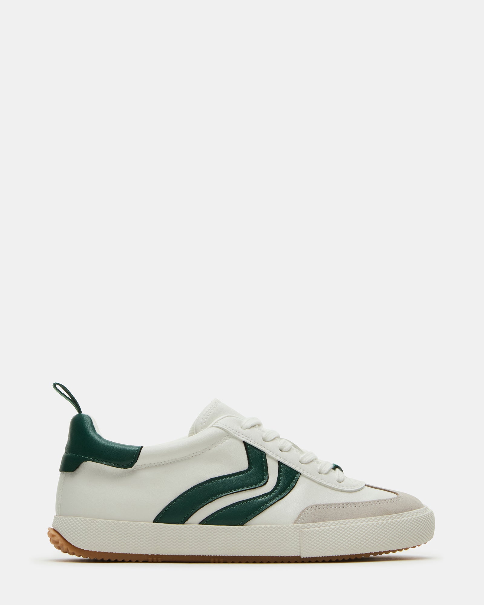 Side view of green low-top shoes on concrete, styled with casual jeans