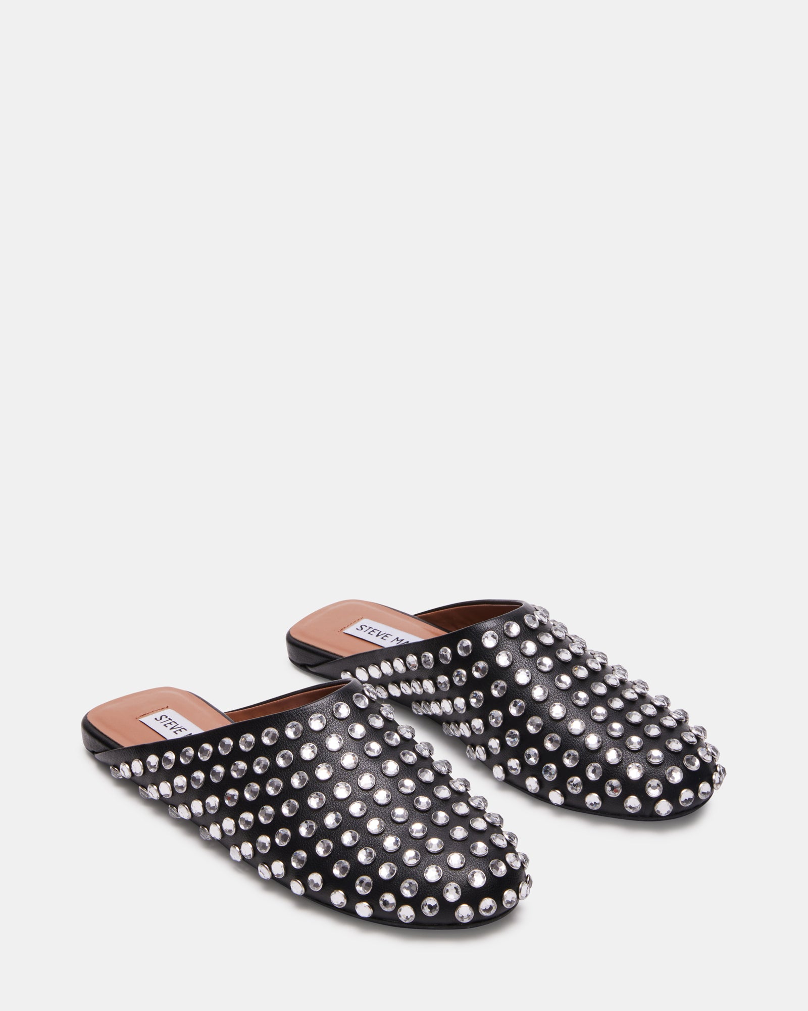 Lifestyle image of someone wearing Glimmer Rhinestones mules on city streets