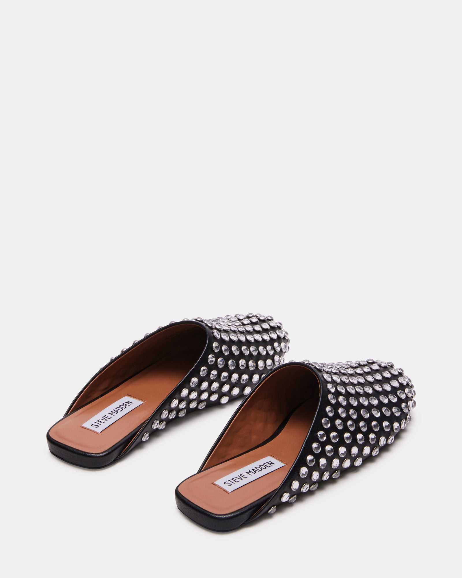 Lifestyle image of someone wearing Glimmer Rhinestones mules on city streets