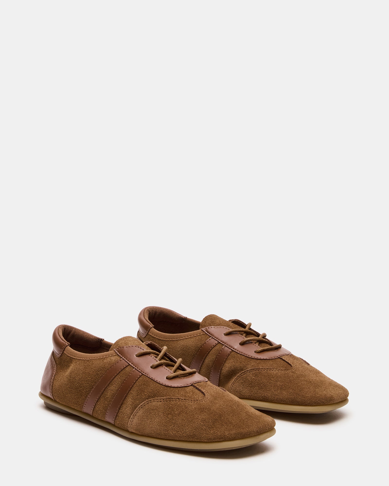 Side angle of suede sneakers, showcasing their sleek design and comfortable fit.