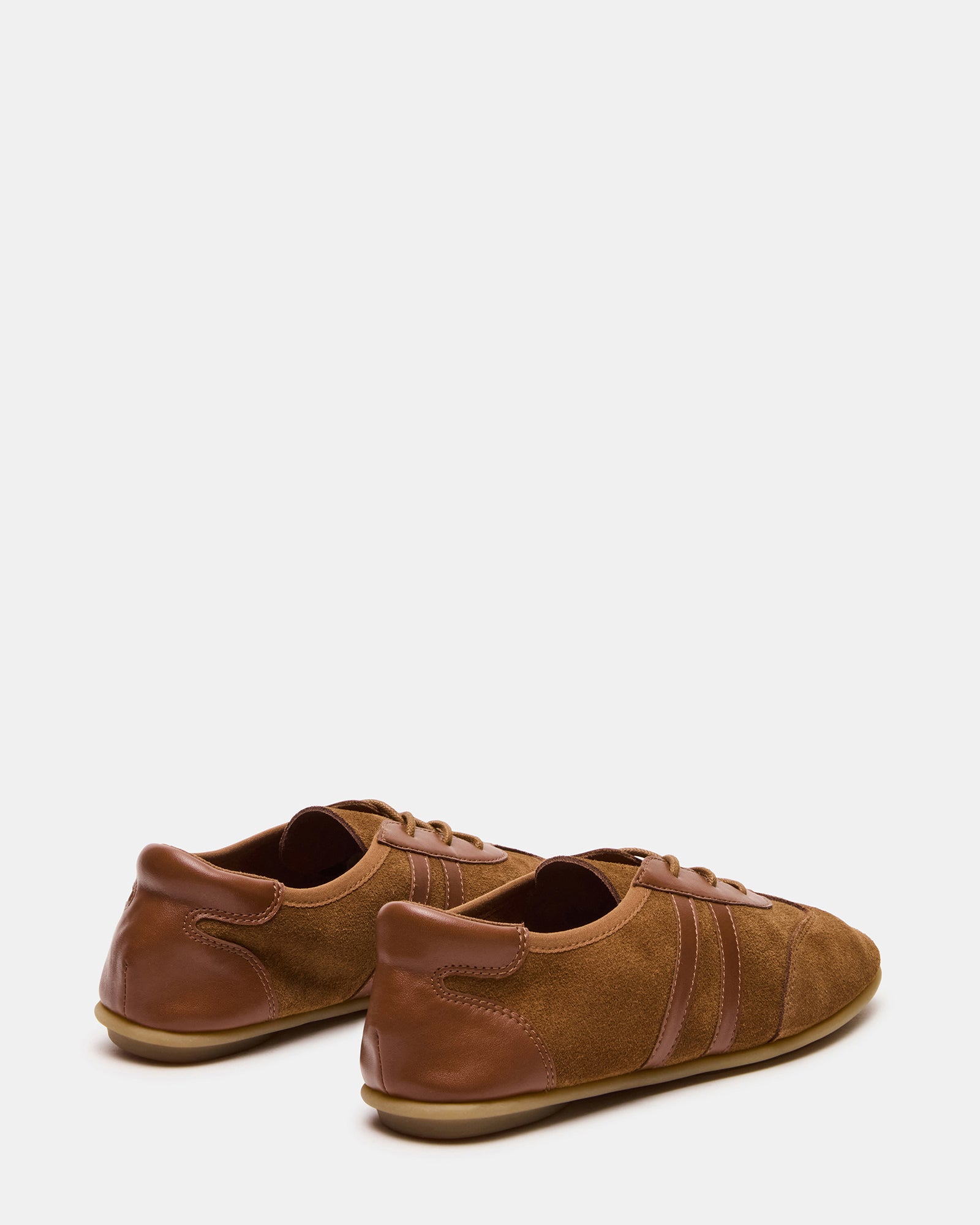 Side angle of suede sneakers, showcasing their sleek design and comfortable fit.
