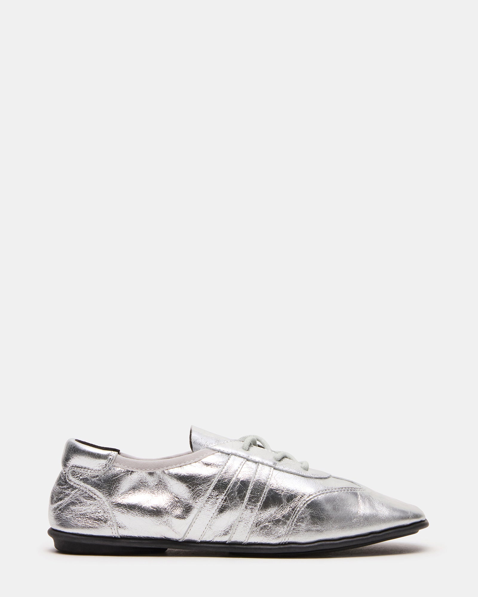 Side profile of silver bottega sneakers styled with rolled denim for casual wear
