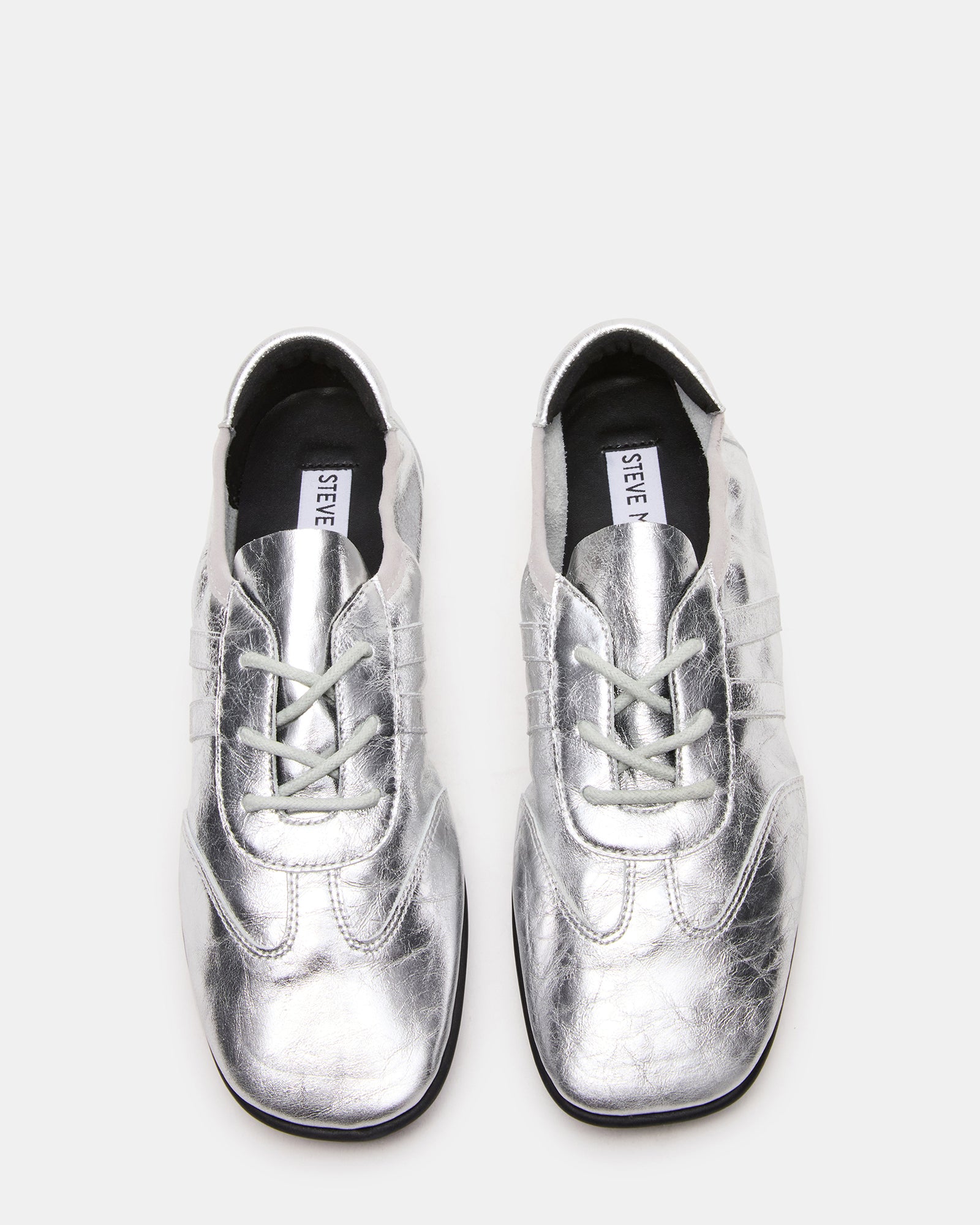 Side profile of silver bottega sneakers styled with rolled denim for casual wear