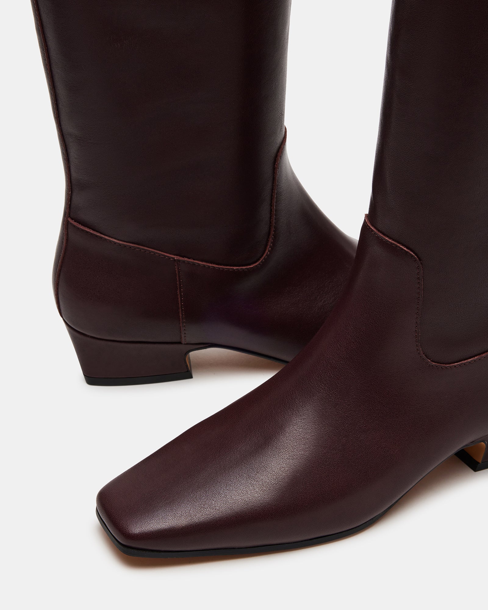 Side view of brown leather boots with square toe and red trim