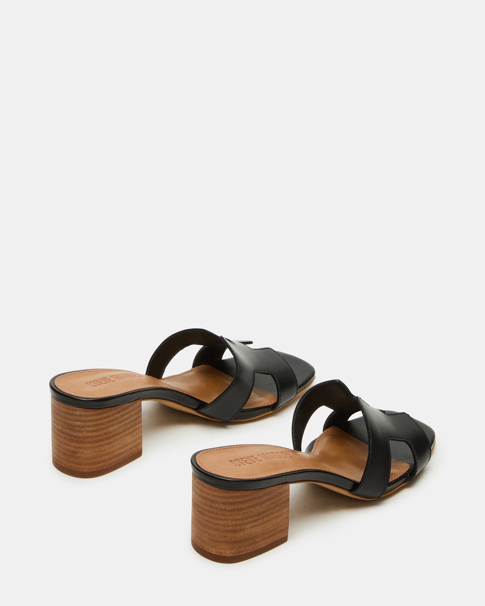 Fashionable black leather sandals worn with a chic outfit for evening events
