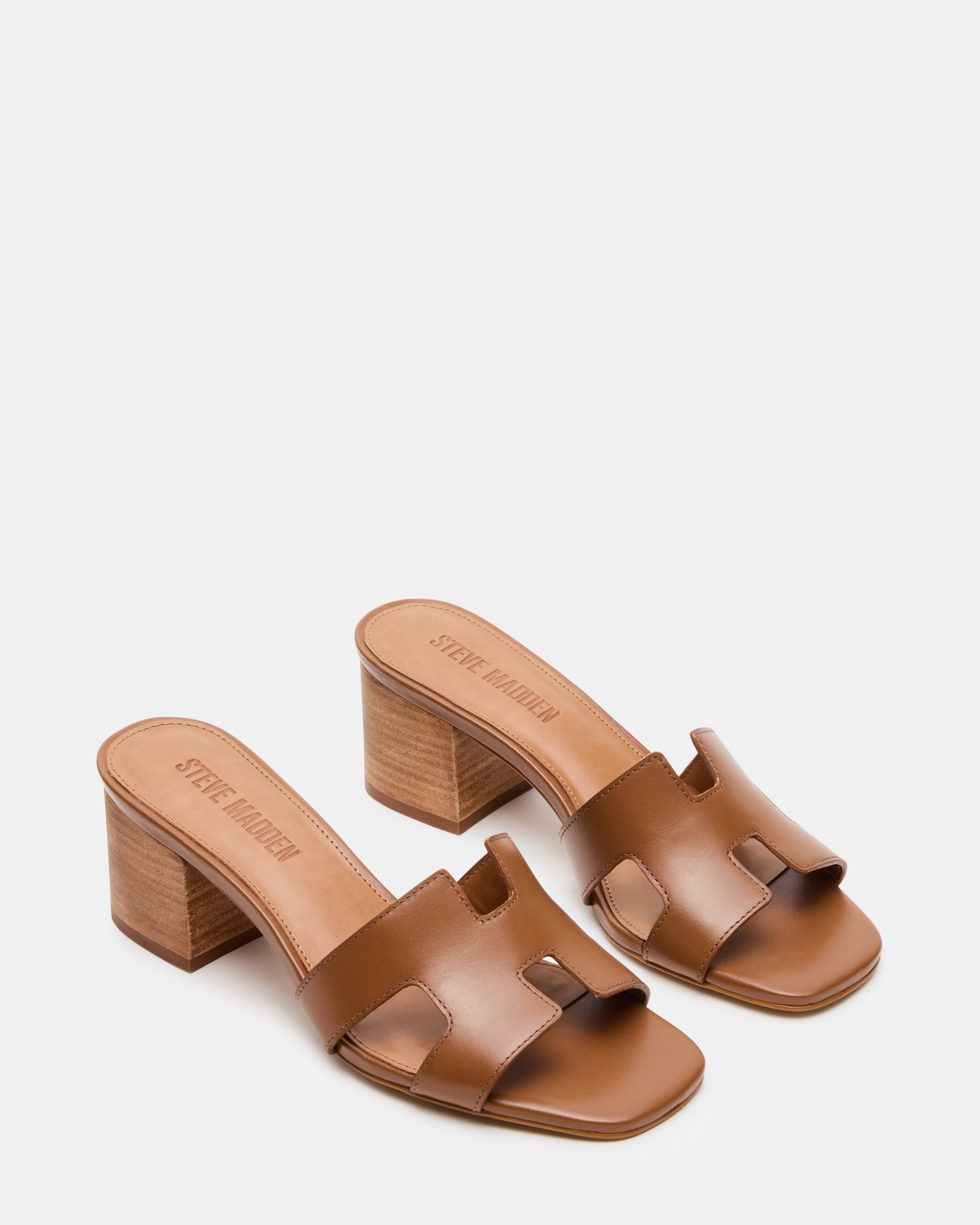 Side profile of nude block heel sandals worn with a flowy skirt for evening style