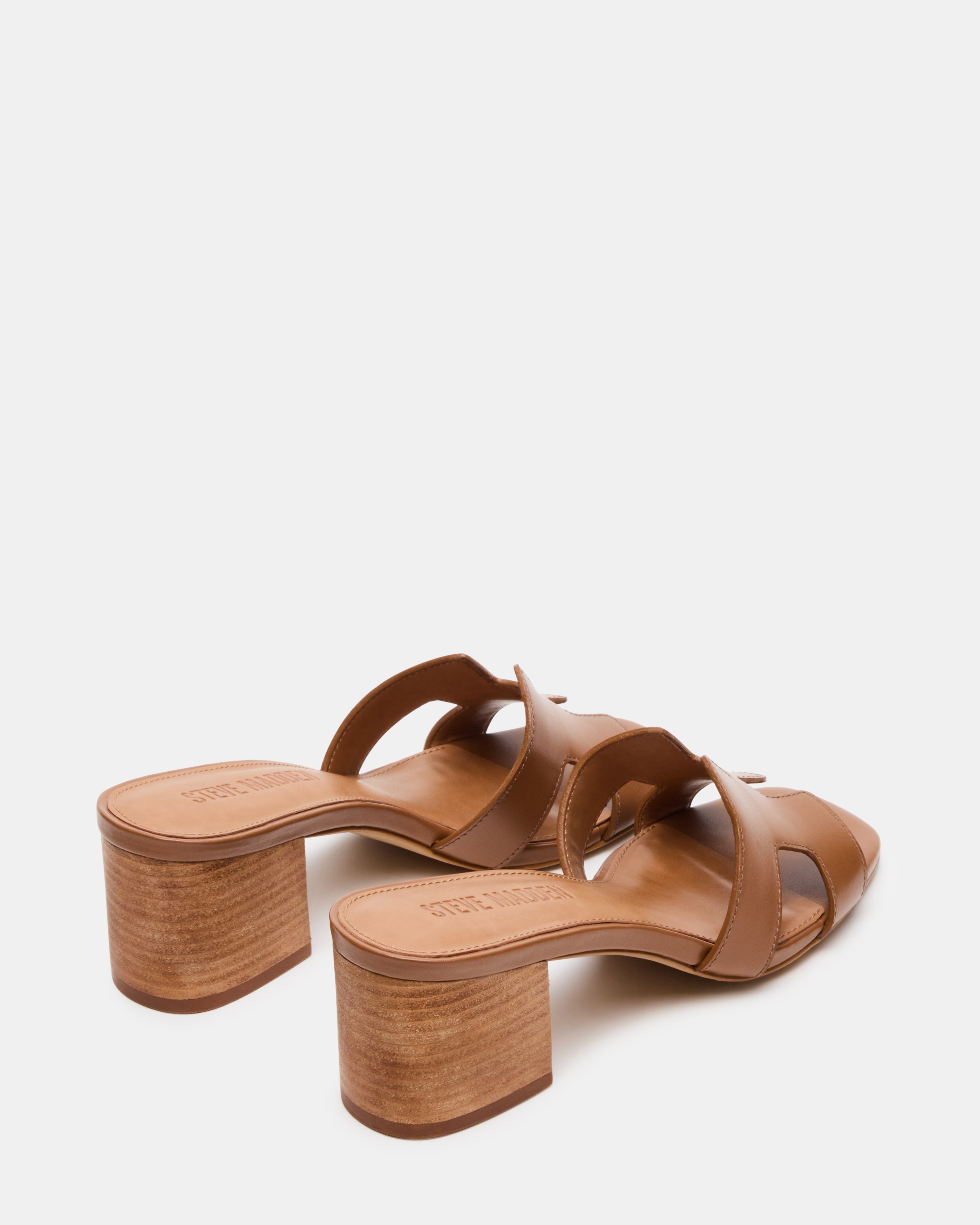 Side profile of nude block heel sandals worn with a flowy skirt for evening style