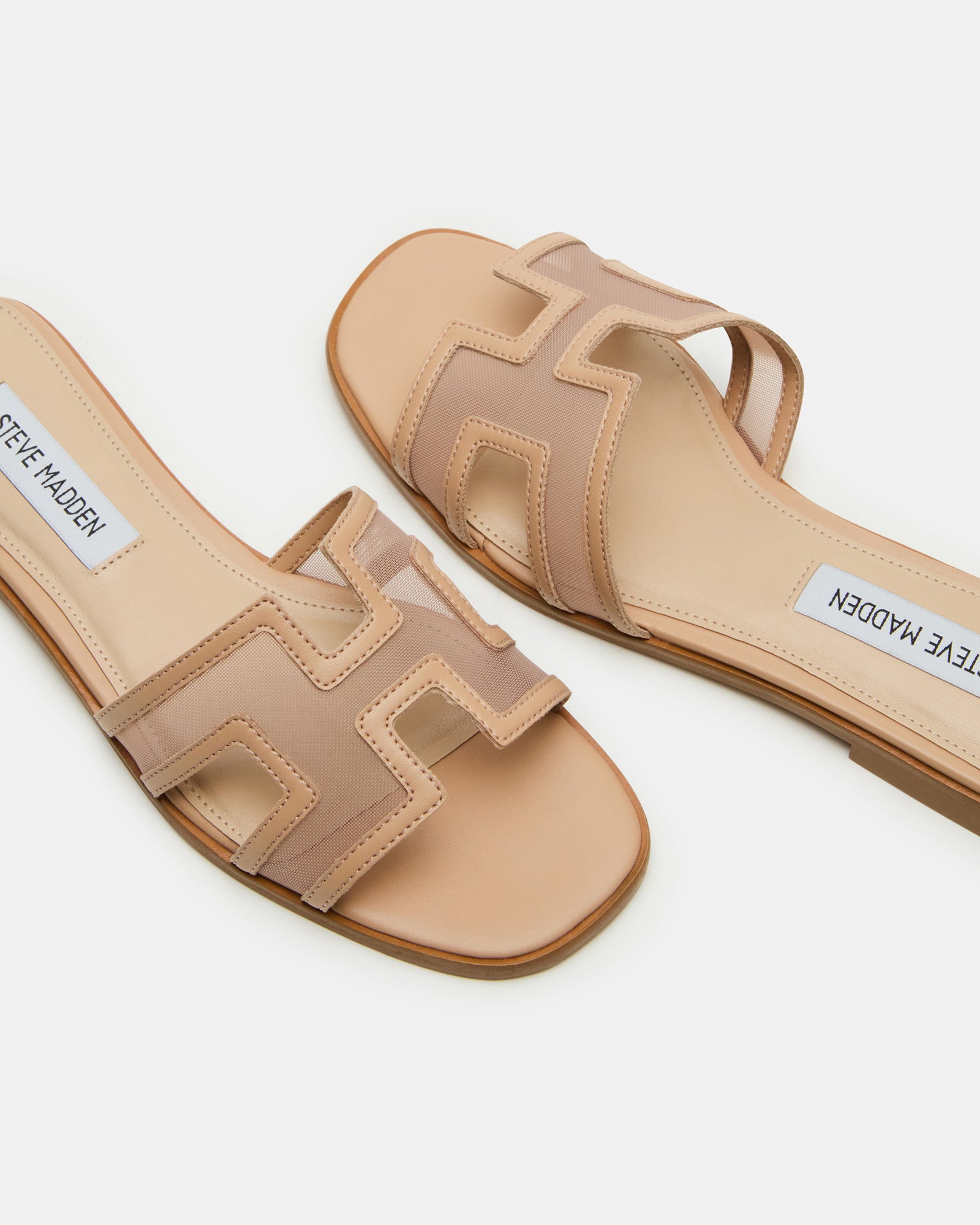 Close-up of gold flat sandals highlighting cutout strap detail