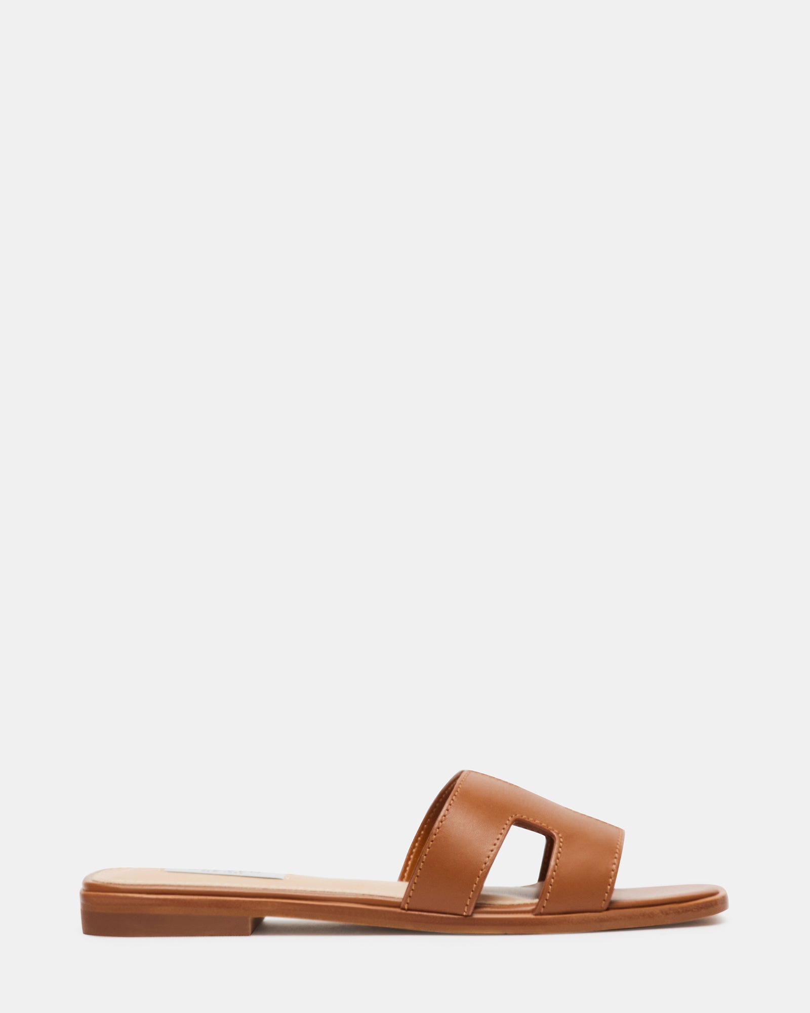 Top view of cognac leather slide sandals showcasing the geometric strap design.
