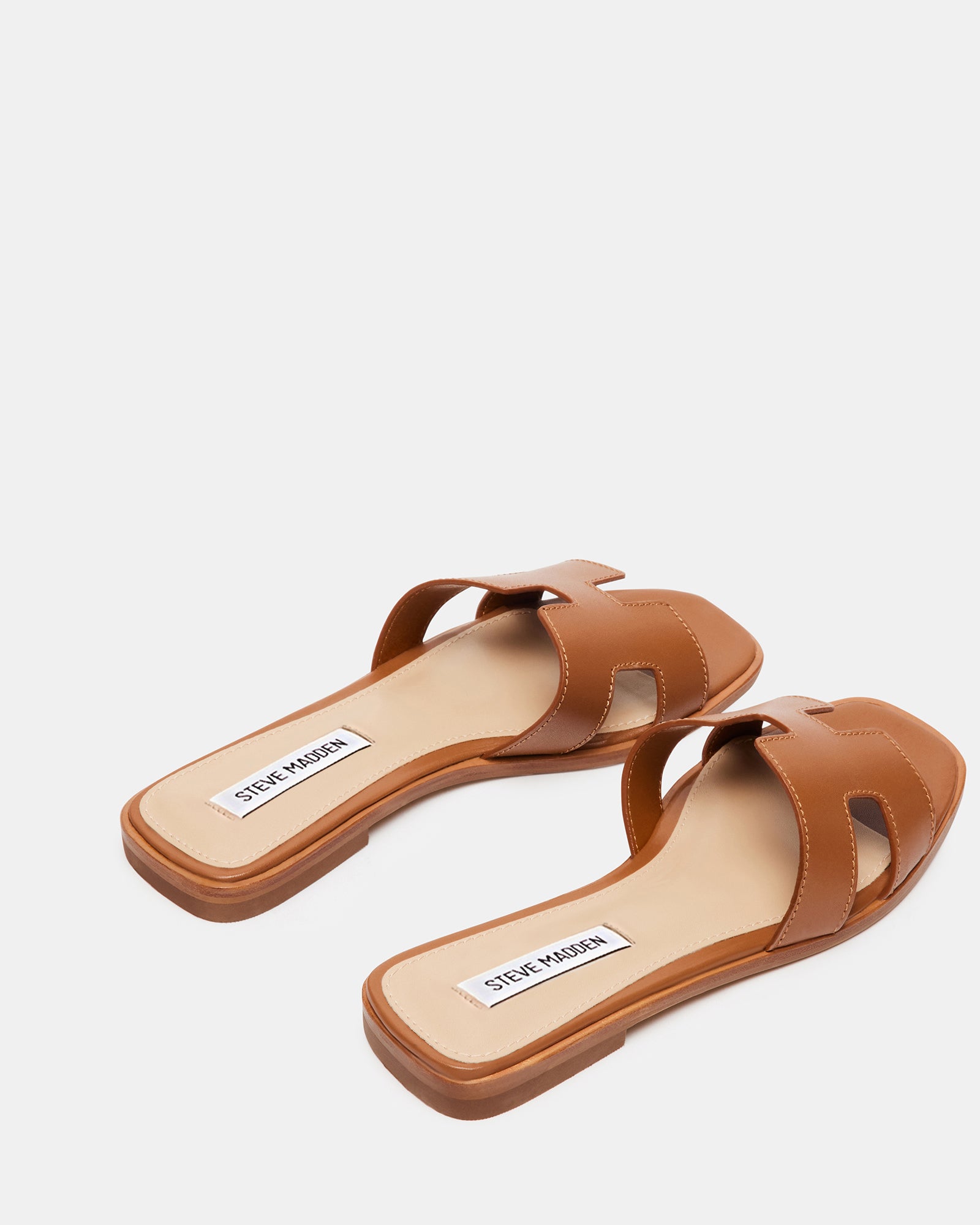 Lifestyle image of womens leather sandals worn with linen pants near the beach.