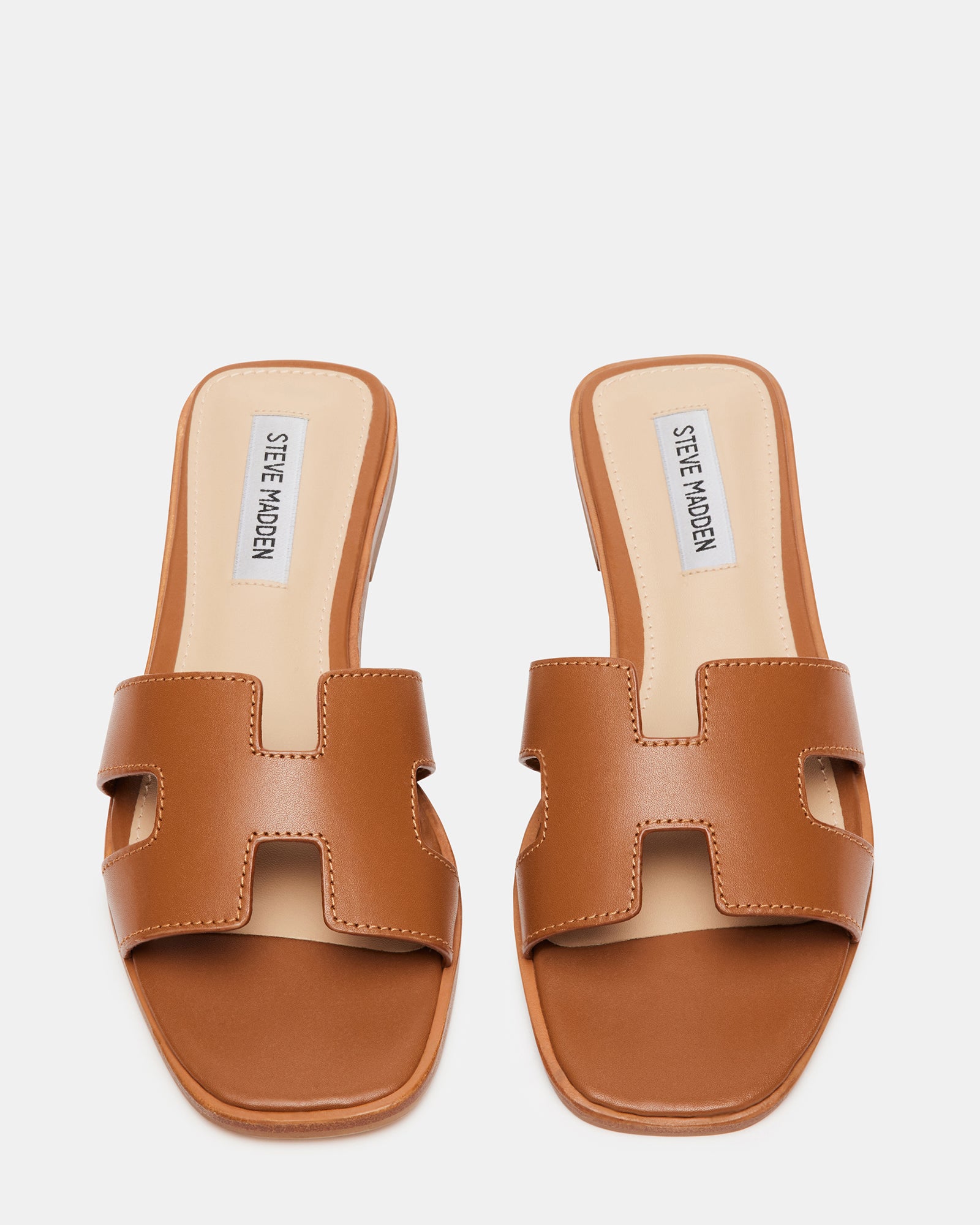 Side angle of slide sandals with a .75 inch heel and cutout strap for casual wear.