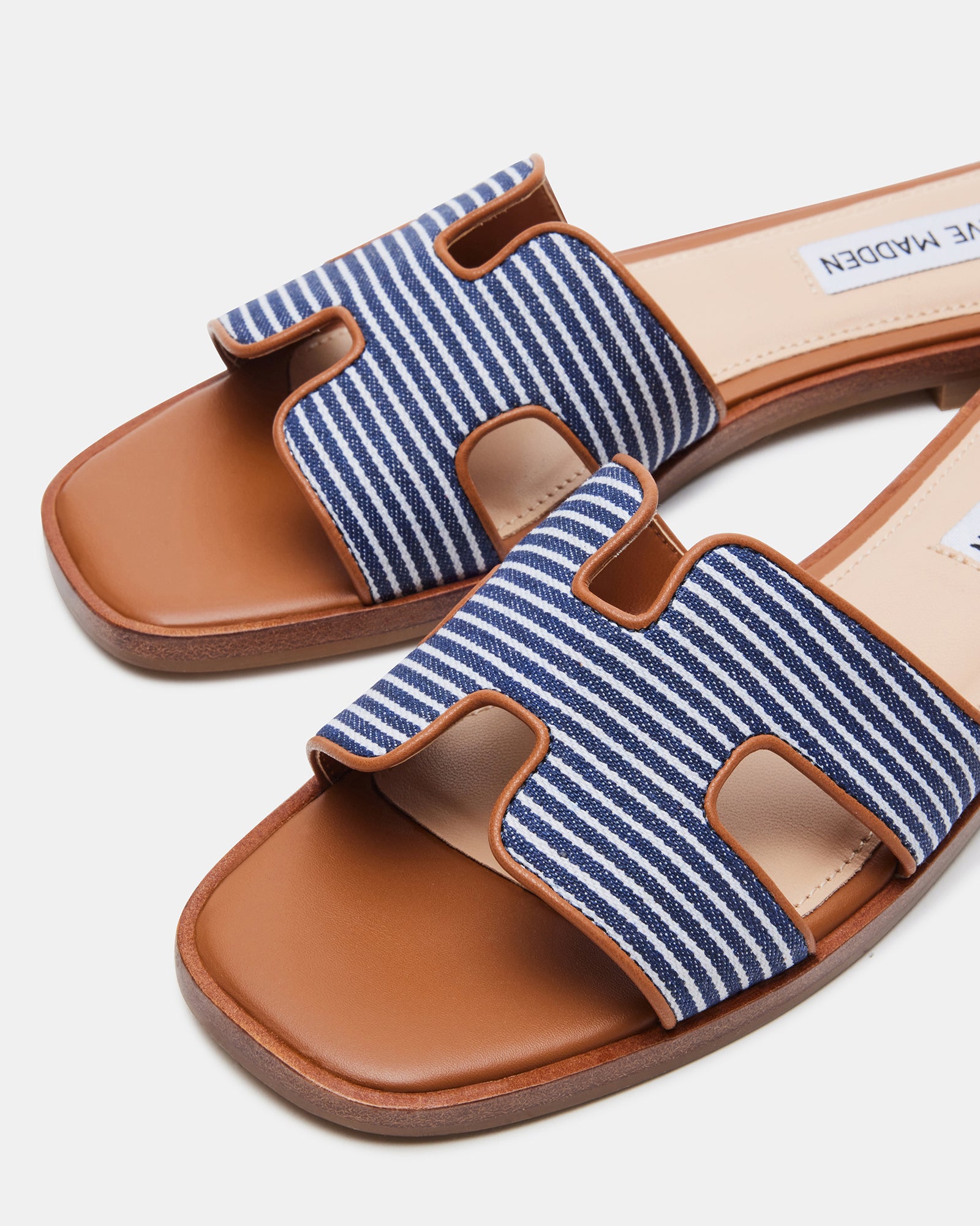 Close-up of navy flat slide sandals featuring cutout strap design