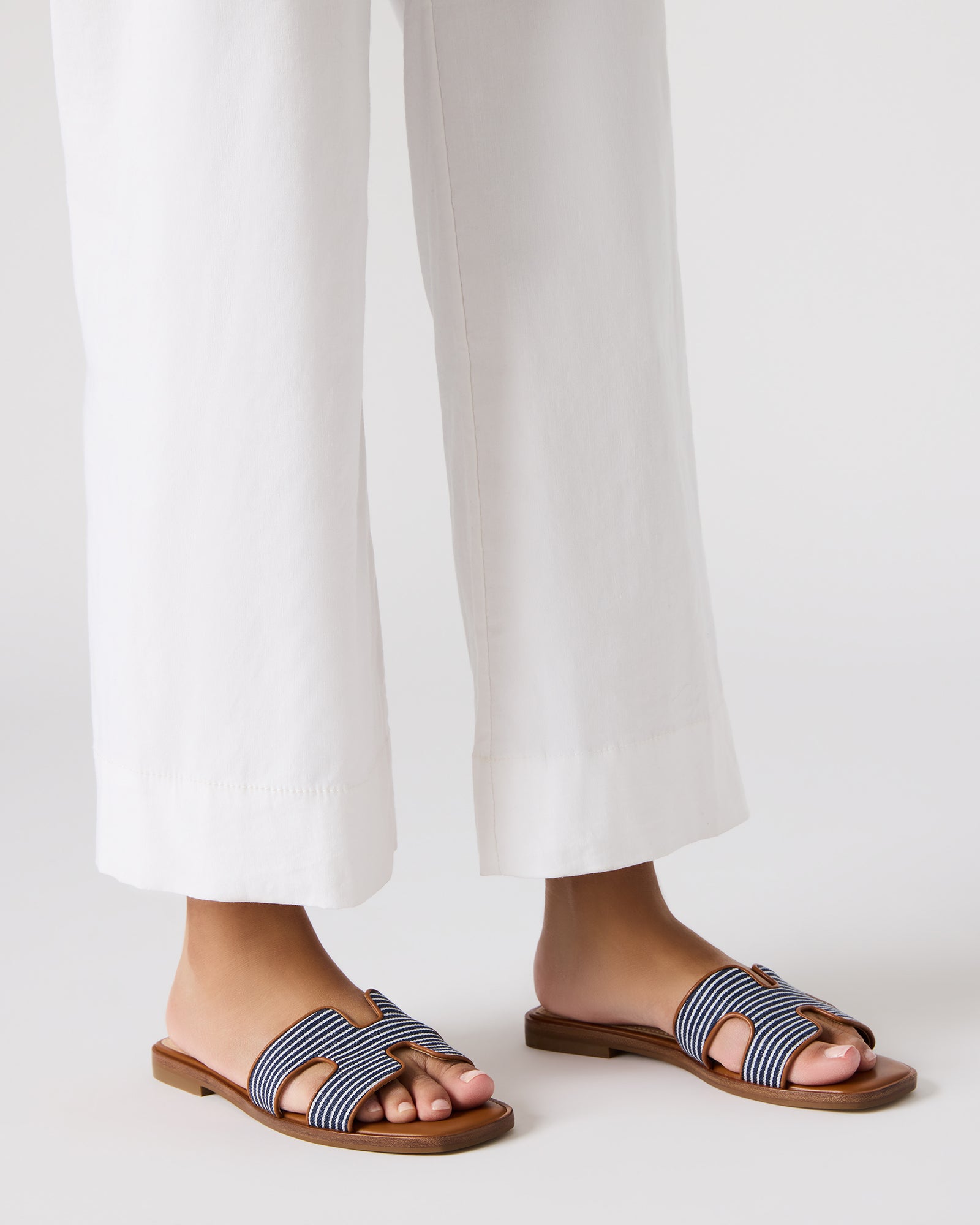 Model wearing navy multi flat slide sandals with a summer dress