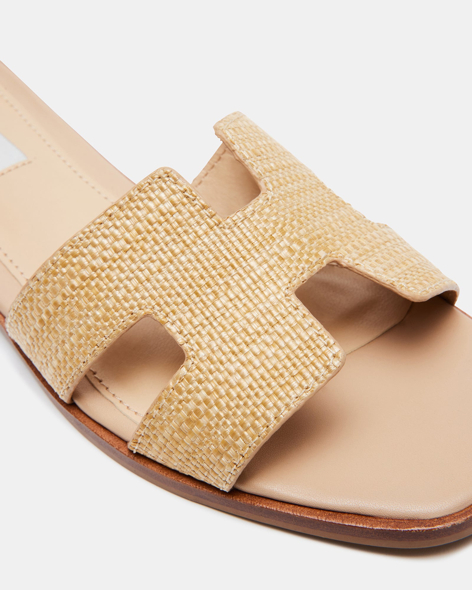 Side view of HADYN Raffia platform slides with geometric cutouts on a sunny outdoor setting