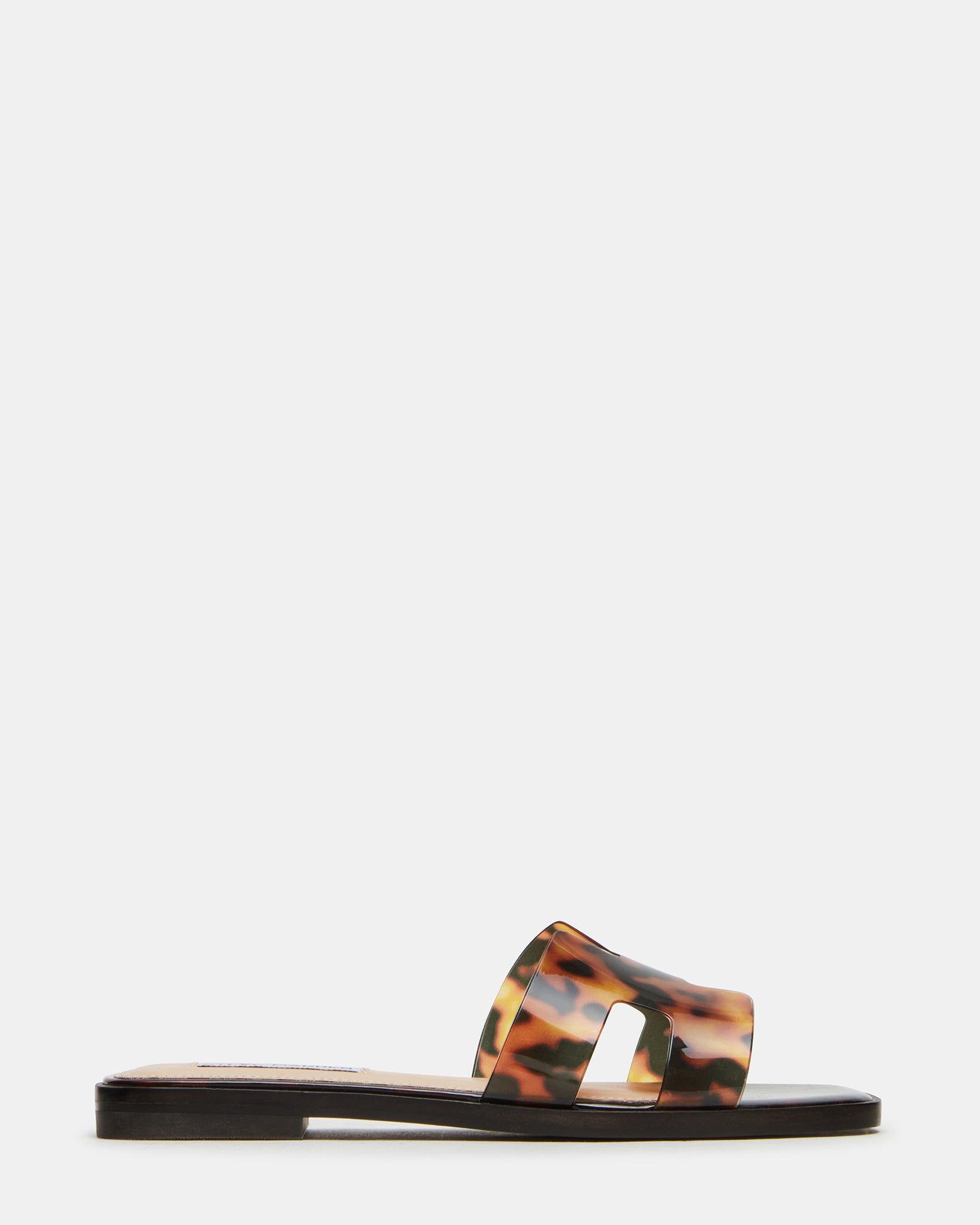 Hadyn gold flat sandals worn with linen pants on cobblestone street