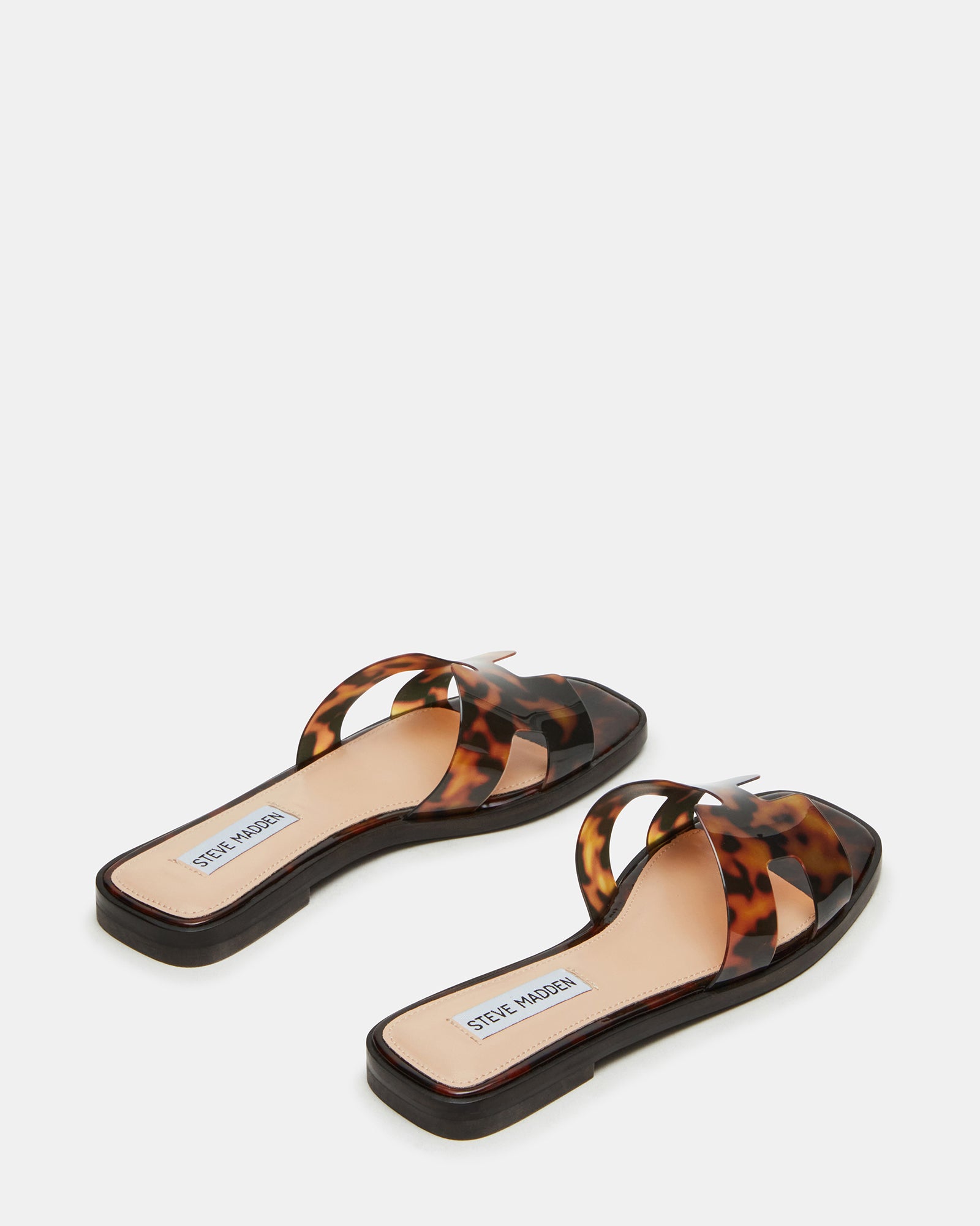 White flat sandals styled with beach towel and woven tote