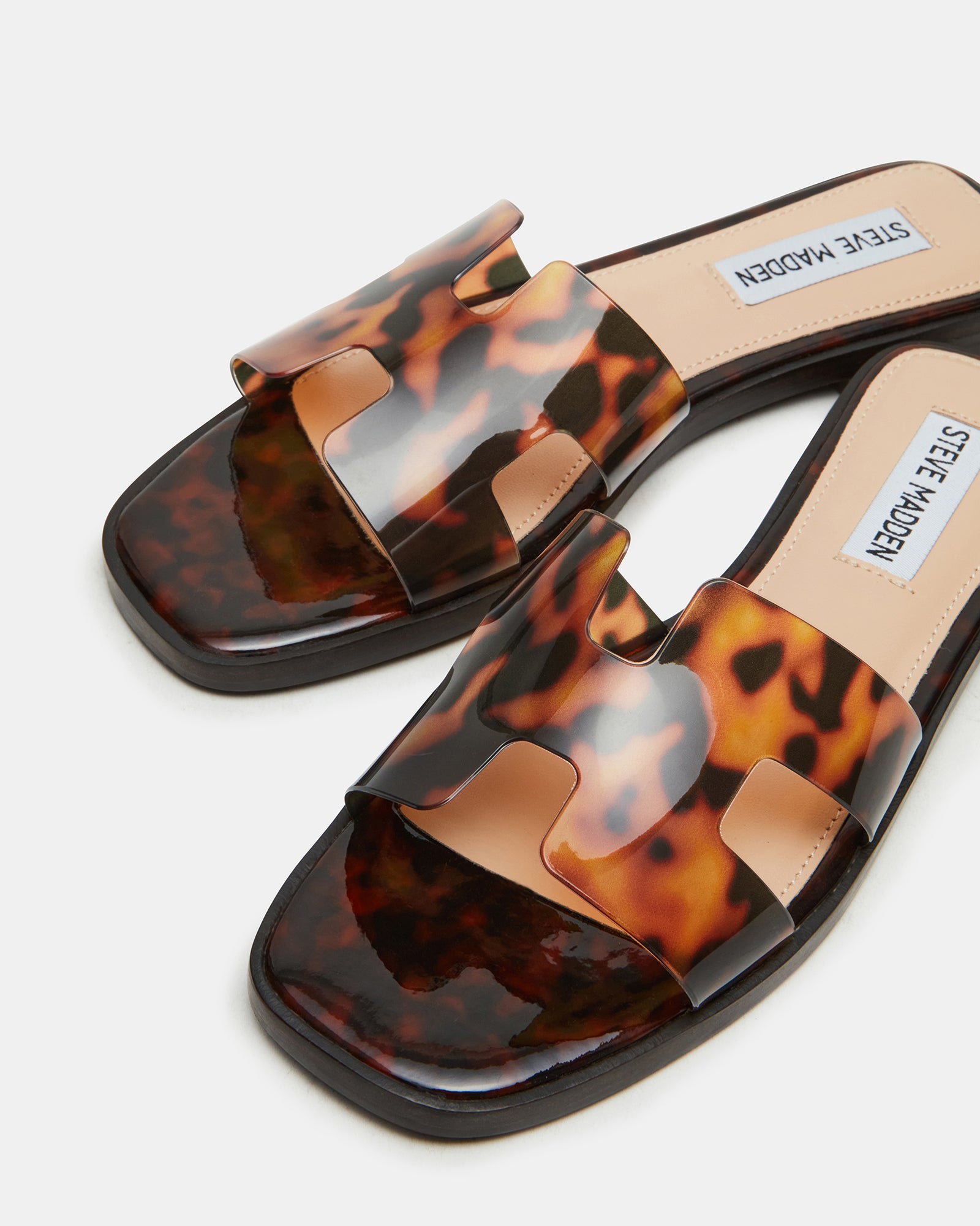 Hadyn gold flat sandals worn with linen pants on cobblestone street