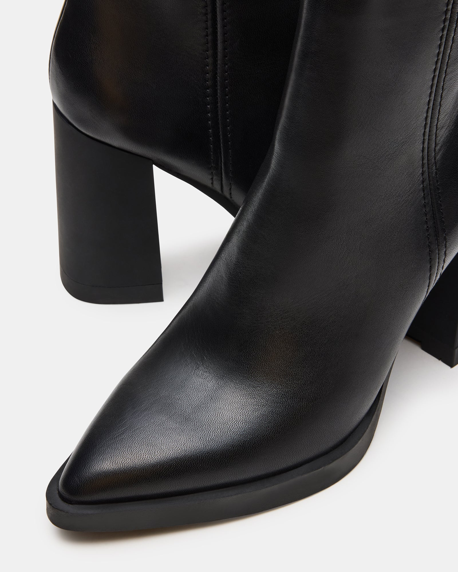 Black suede ankle boots styled with cuffed jeans for a casual look.
