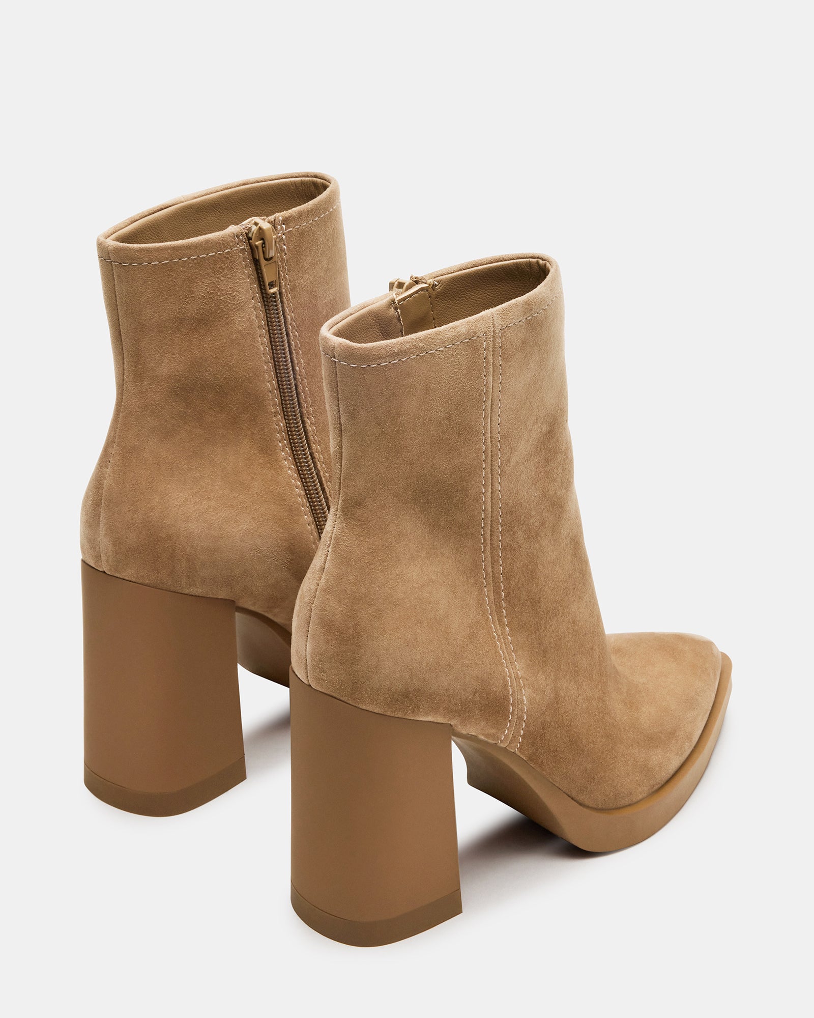Model wearing brown suede ankle booties paired with casual attire.