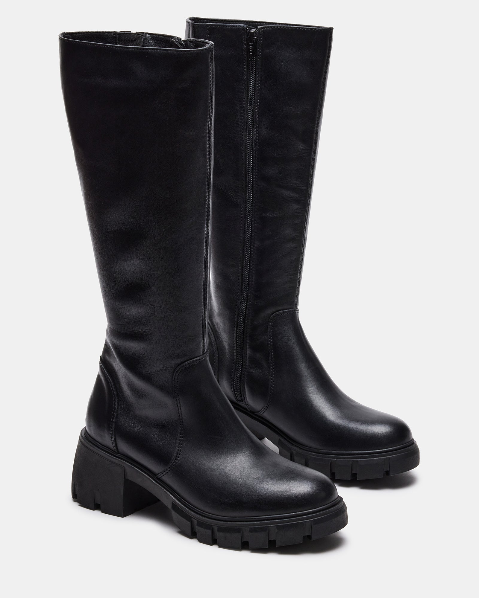 Close-up of lug sole treads on black leather boots