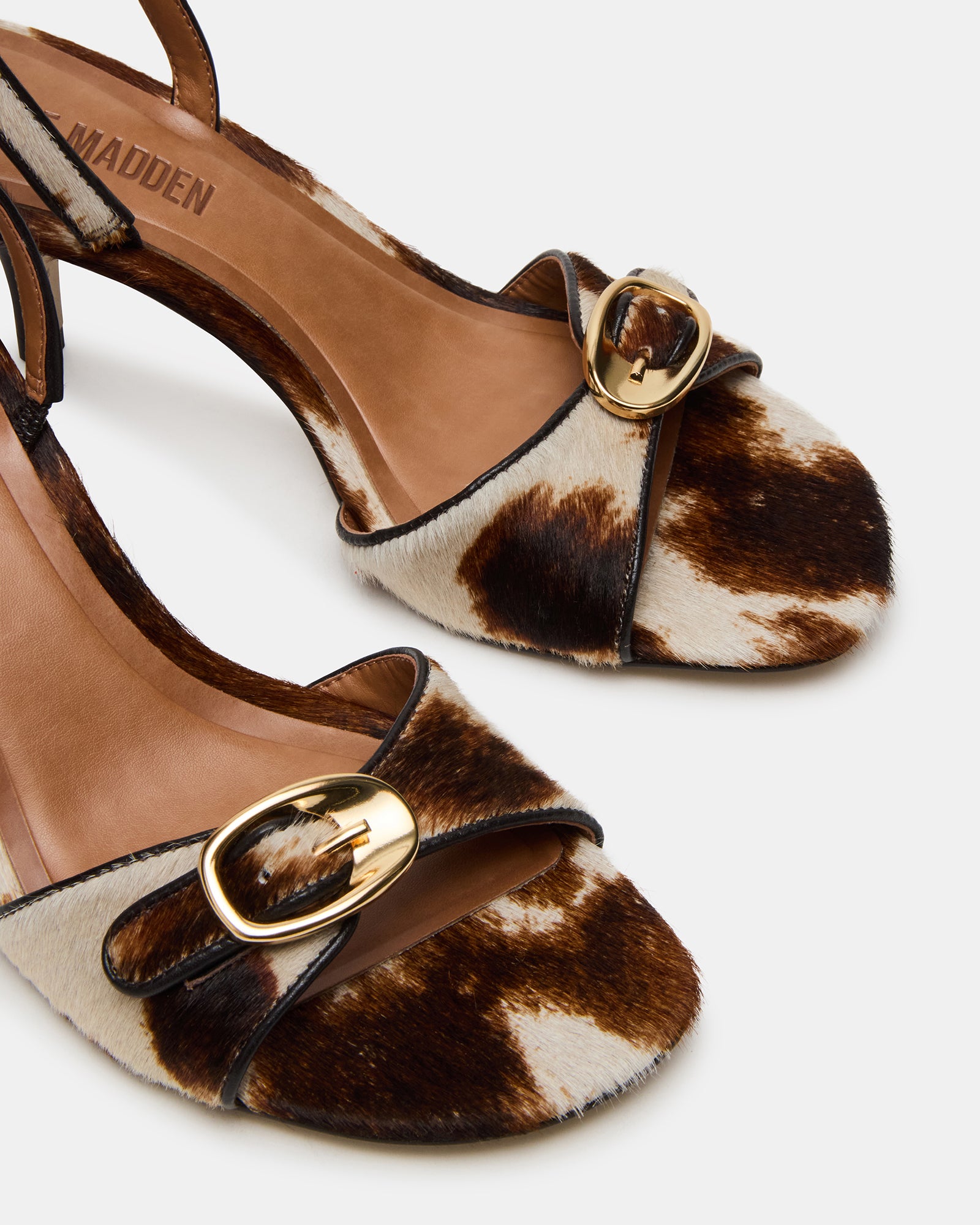 Styled outfit featuring brown leather wedge heels with cow print for casual elegance