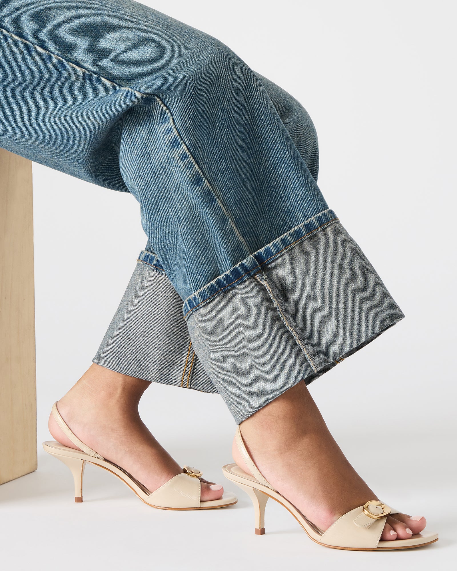 Woman wearing white slingback heels walking on cobblestone street