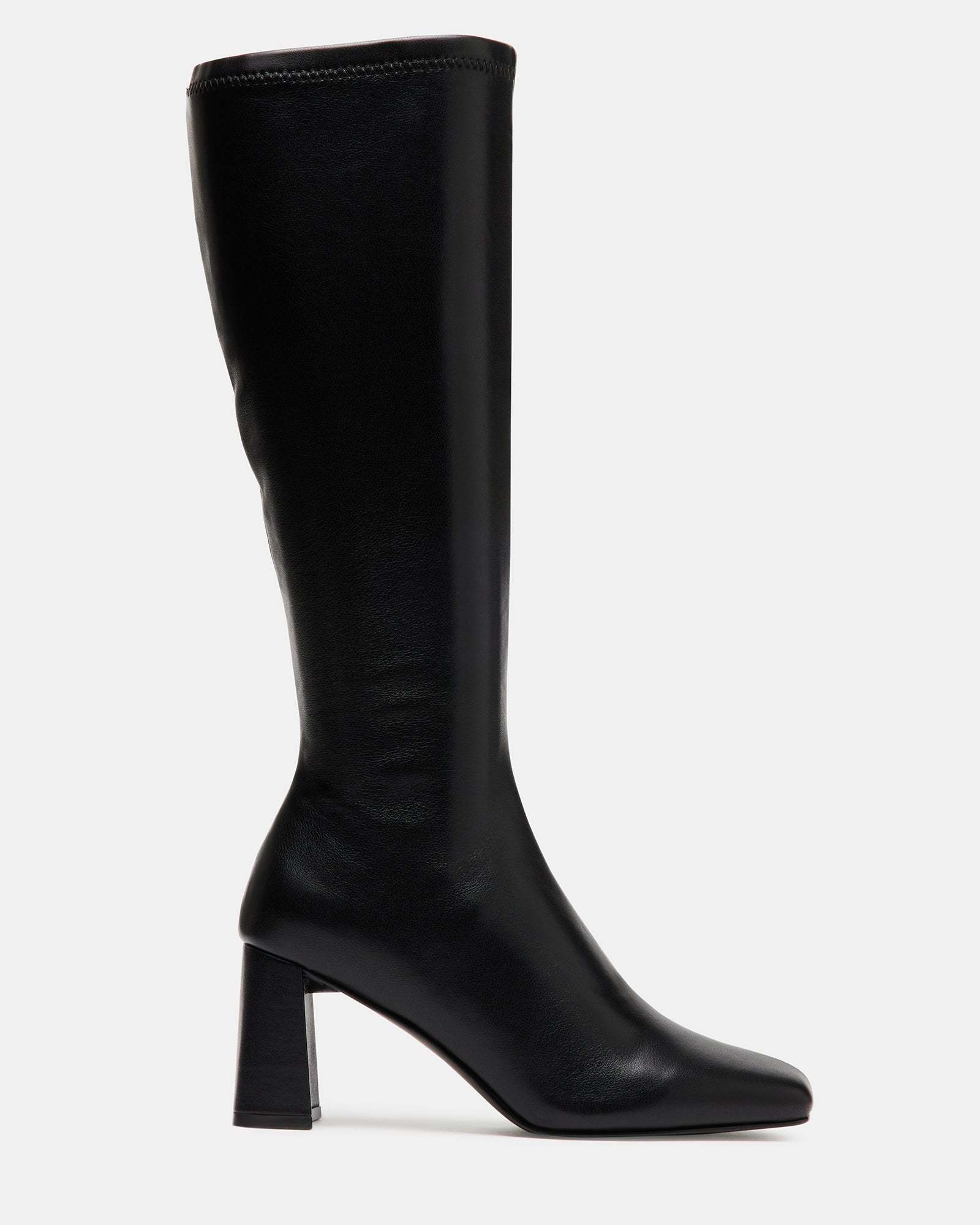 Front view of black block heel ankle boots styled with a wool coat on a New York sidewalk.