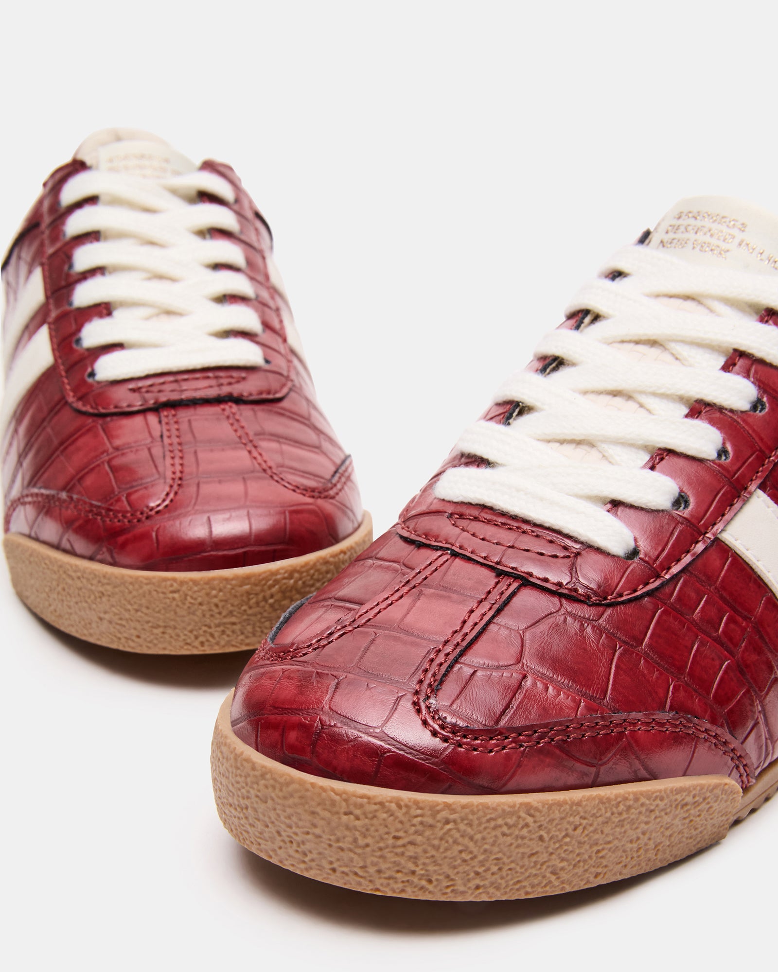 Close-up of HUDSIN Red Crocodile low-top sneakers showcasing lace-up design.